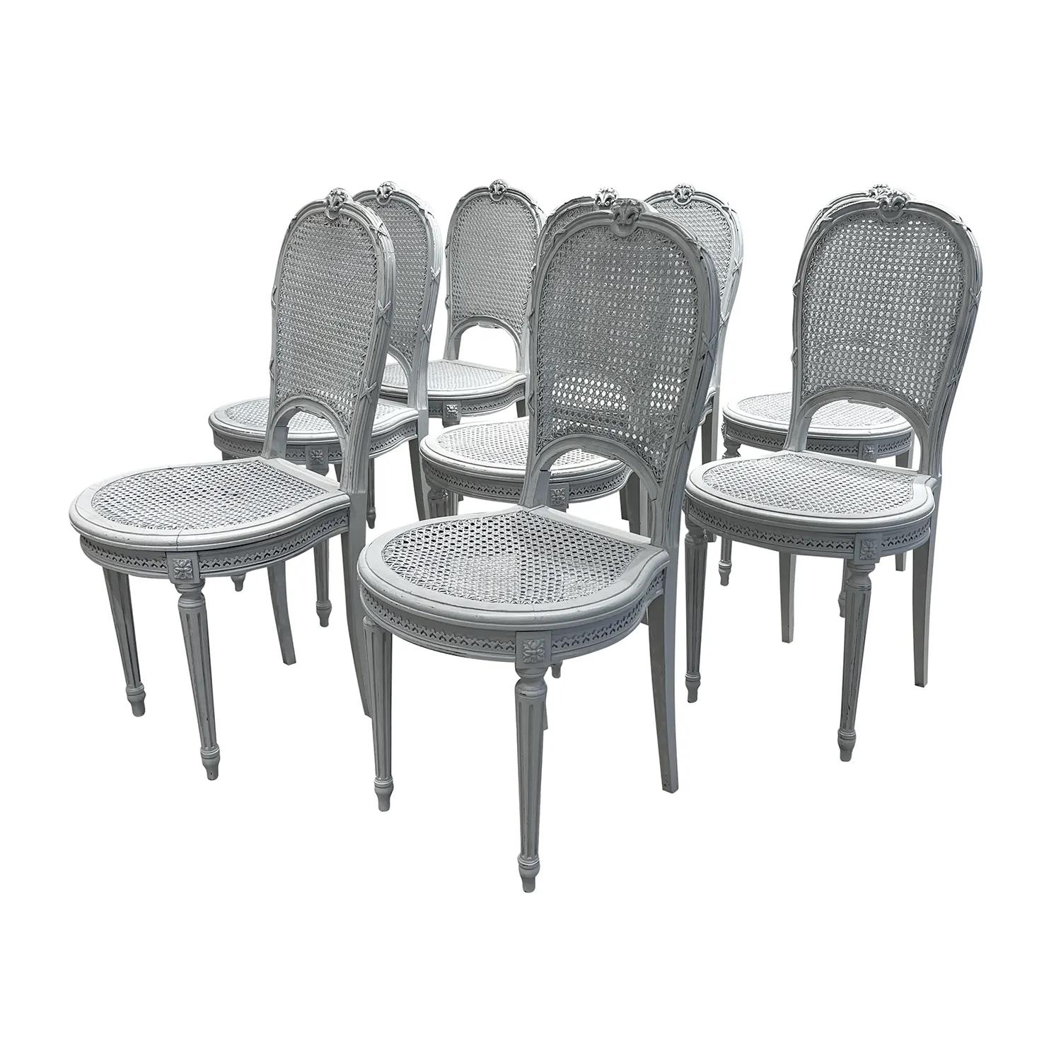 Antiker Satz von acht Esszimmerstühlen im Stil Louis XVI aus handgeschnitztem Kiefernholz, in gutem Zustand. Die skandinavischen Beistellstühle in kalkgrauem Finish haben eine abgerundete Rückenlehne aus Schilfrohr, eine Sitzfläche aus Schilfrohr