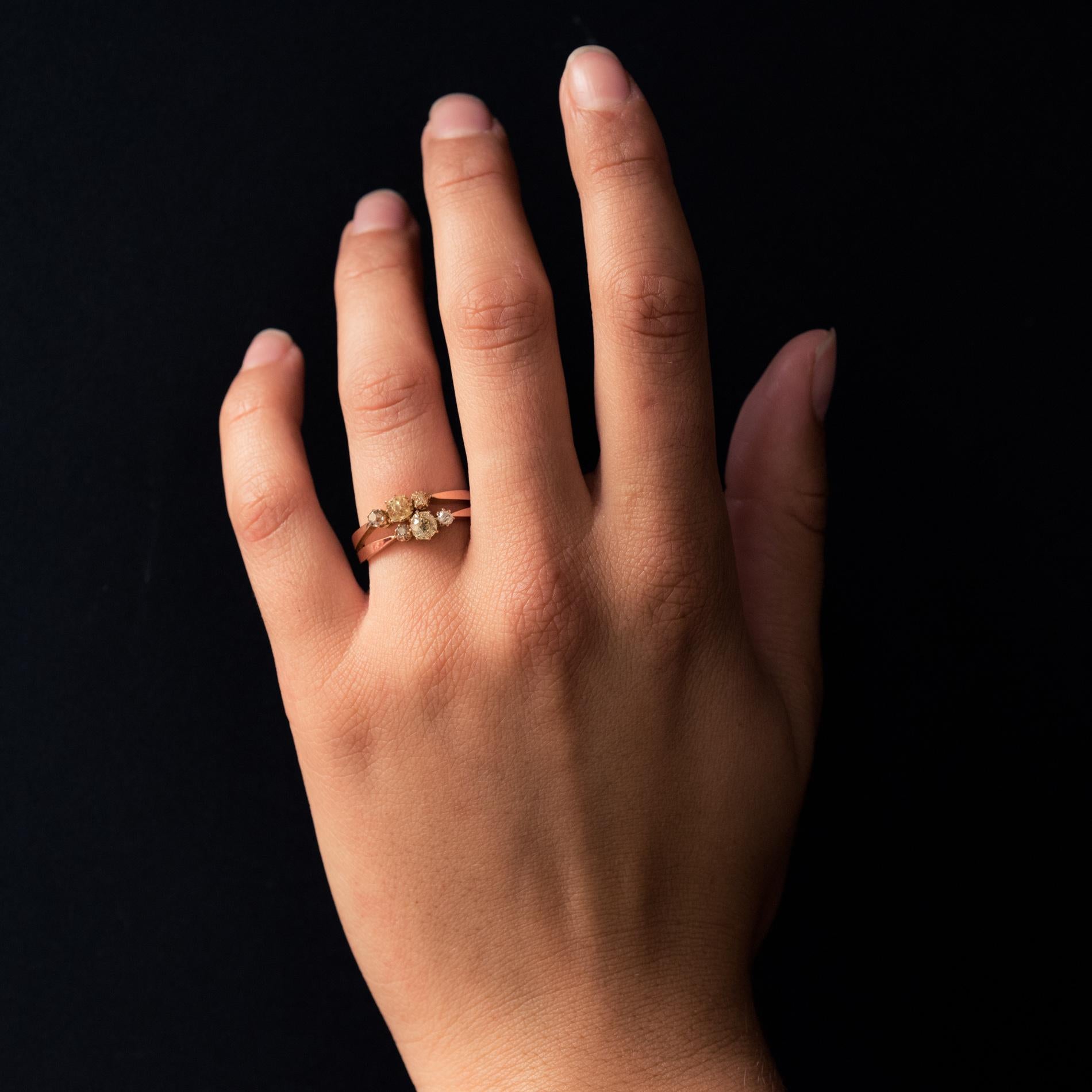 Ring in 18 karat rose gold.
Feminine antique ring, it is formed by 2 flat gold threads which are refined on the top and each hold an antique cushion- cut diamond shouldered on either side of two antique cut diamonds. One of the main diamonds is