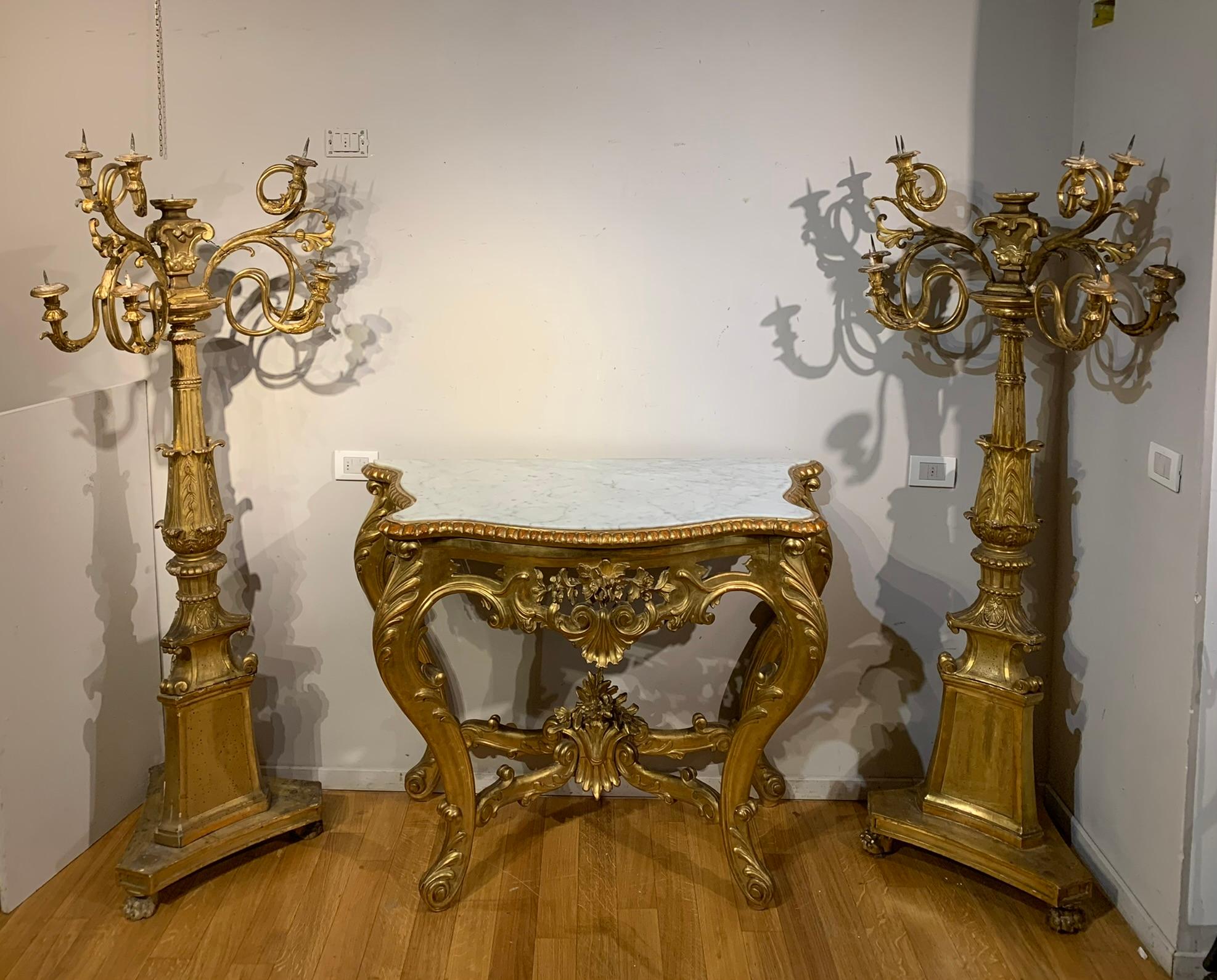 Beautiful wooden console carved with floral motifs, worked with great skill and refinement. Its elegance is accentuated by the pure gold gilded finish, which gives it a bright and luxurious appearance. It is a wall cabinet, designed to be fixed to