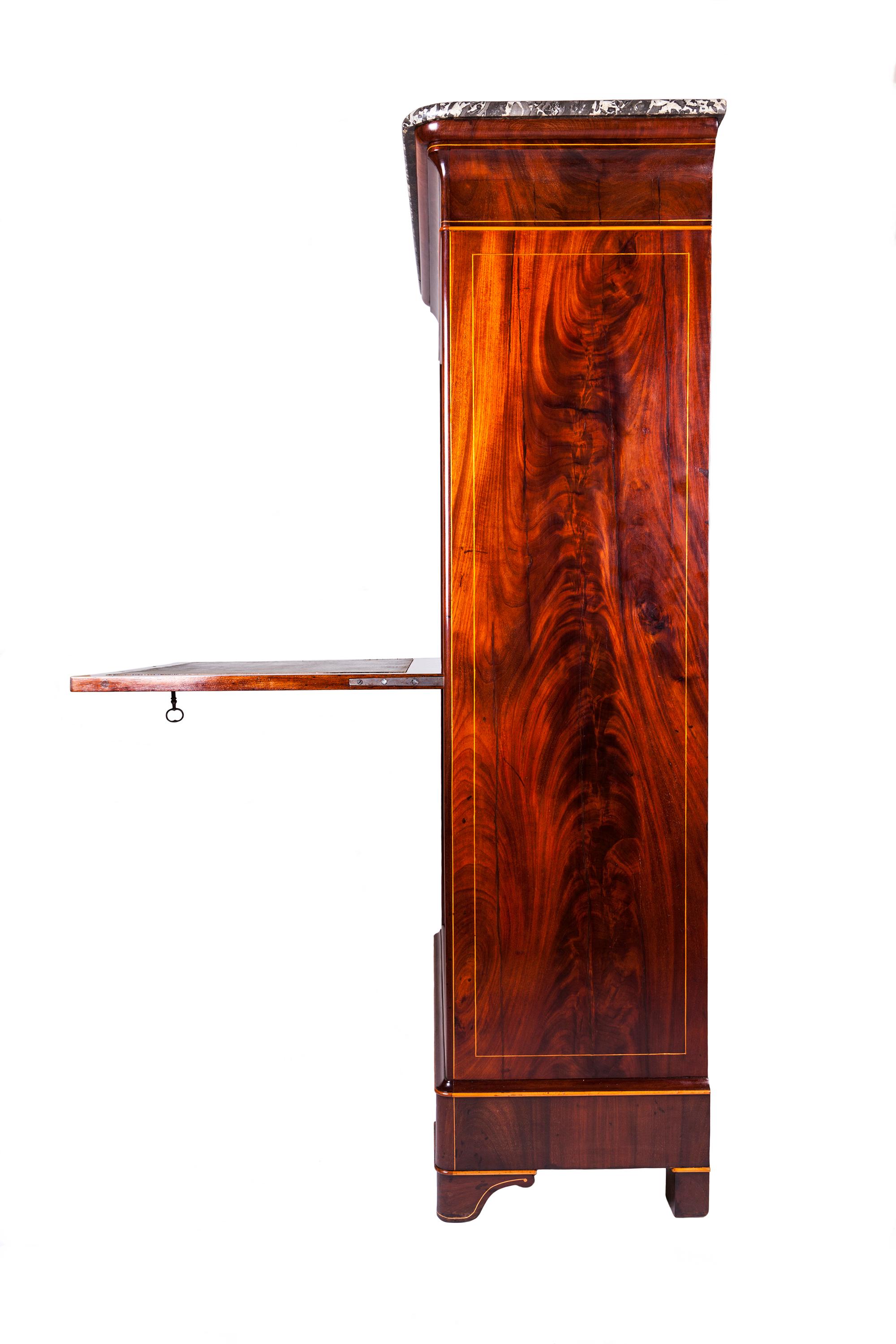 Rare secrétaire à abattant Carlo X, in flamed mahogany wood, finely inlaid in light wood with palmette and lyre motifs in the typical taste of Carlo X style. Calatoia is covered with a beautiful original printed leather. Locks and keys are