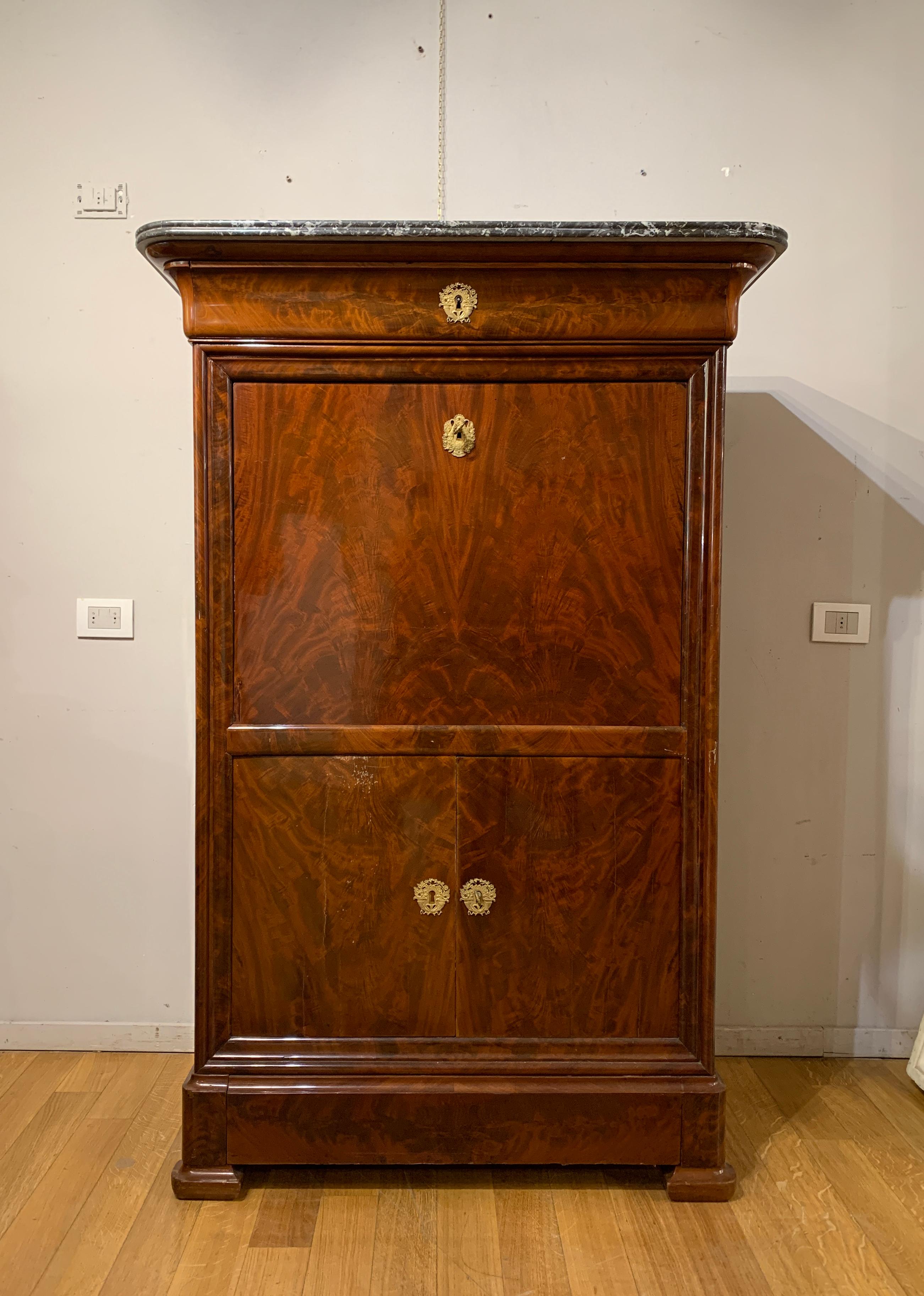Élégant secrétaire en plume d'acajou avec intérieur marqueté en bois d'érable. Le meuble comporte quatre tiroirs sur la façade, dont le deuxième peut être ouvert. L'intérieur comporte des incrustations de décorations phytomorphes et six tiroirs. Les