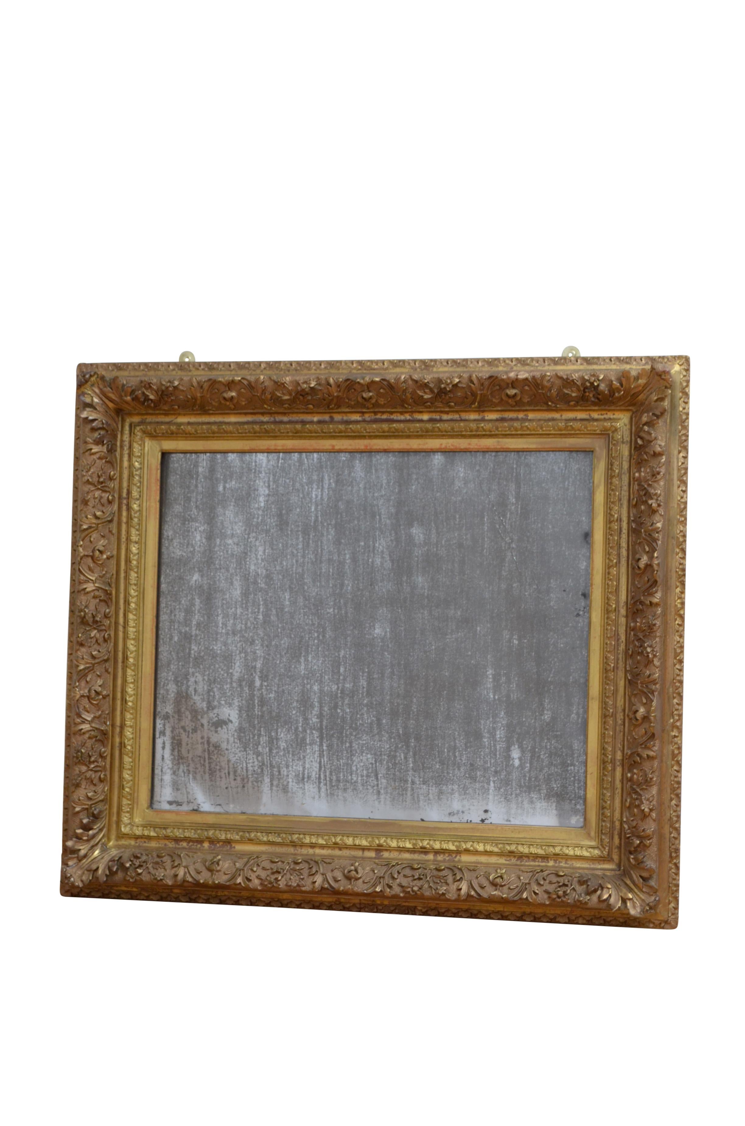 K0516 Espléndido espejo de pared de madera dorada del siglo XIX, con cristal bellamente envejecido con fuerte graduación plateada y otras imperfecciones en un marco dorado finamente tallado con motivos florales, hojas y volutas. Puede colocarse