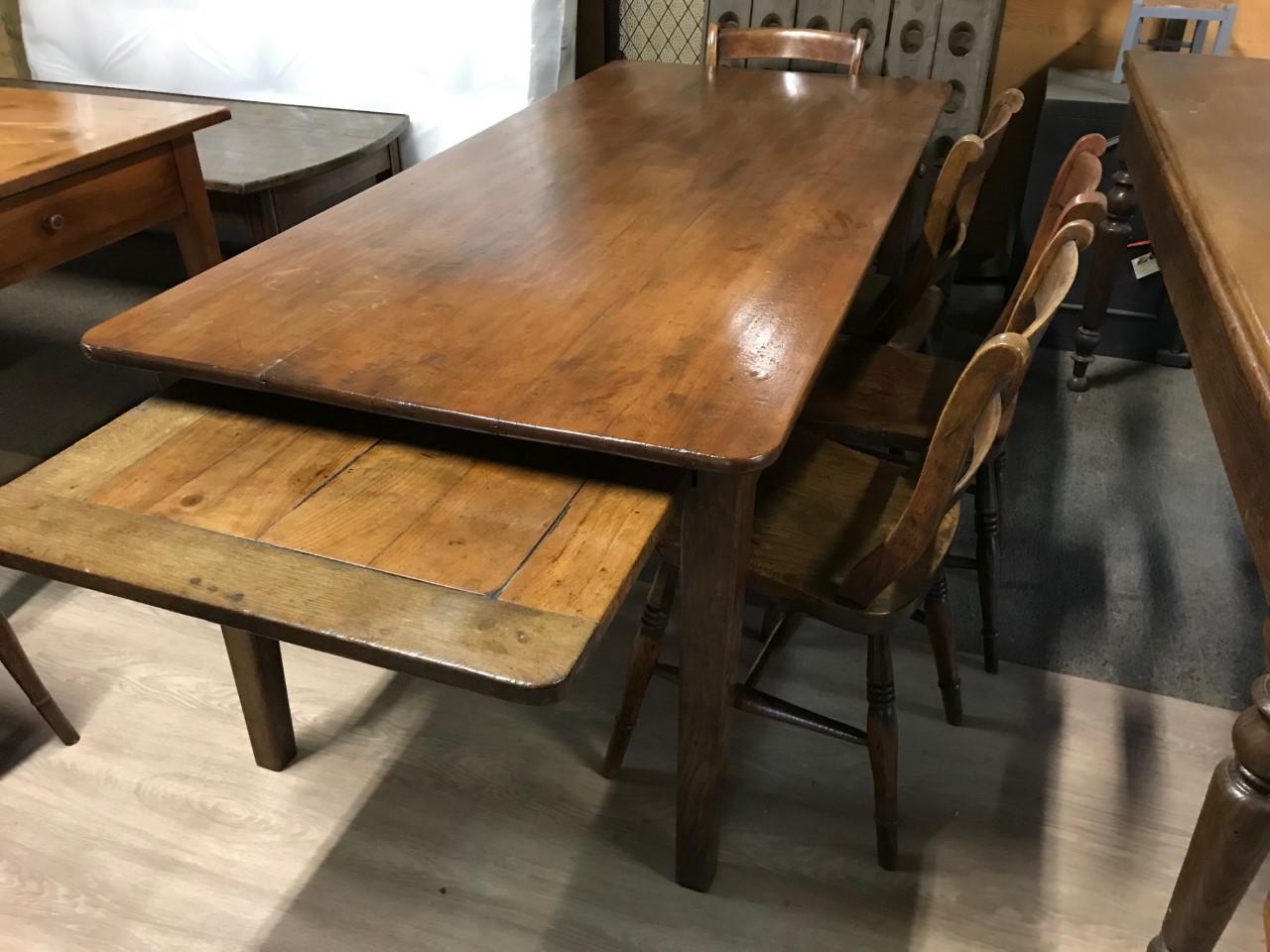 19th century cherry dining table with bread slide and one side drawer. The table has a beautiful top and sits on a sturdy base with tapered legs. Lovely warm cherry in color and stands really well.

 