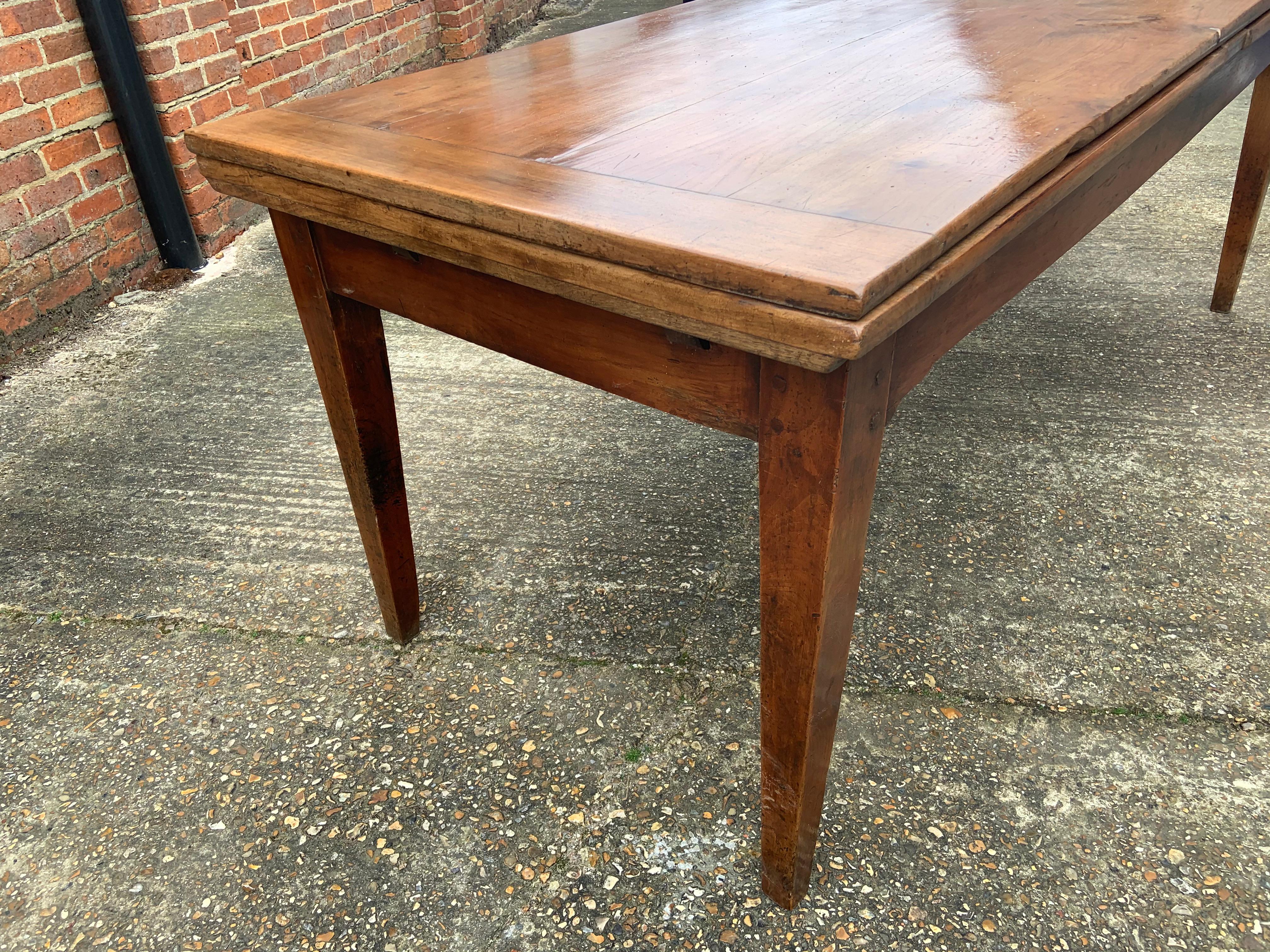19th century cherry double extending farmhouse table with gorgeous patination and colour. The sits on four sturdy tapered legs. When closed table is 2m in length and open it is 388cm long. You can use one leaf at a time or both to fully extend