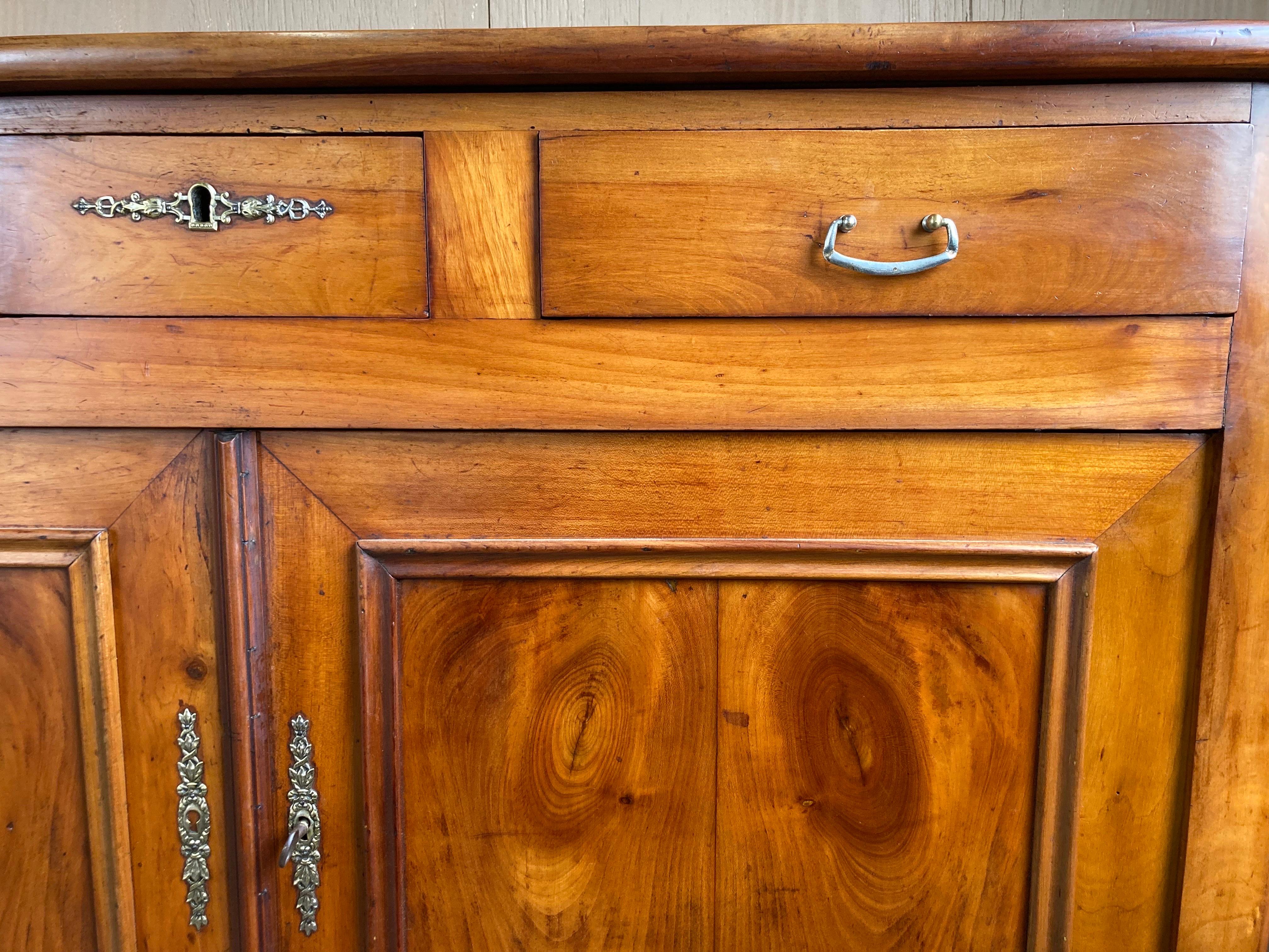 Louis Philippe buffet hand crafted in France in the mid 1800s using cherry and pegged construction. This is a beautiful, elegant piece both because of proportions and color. As typical of the Louis Philippe style the buffet has very straight lines,