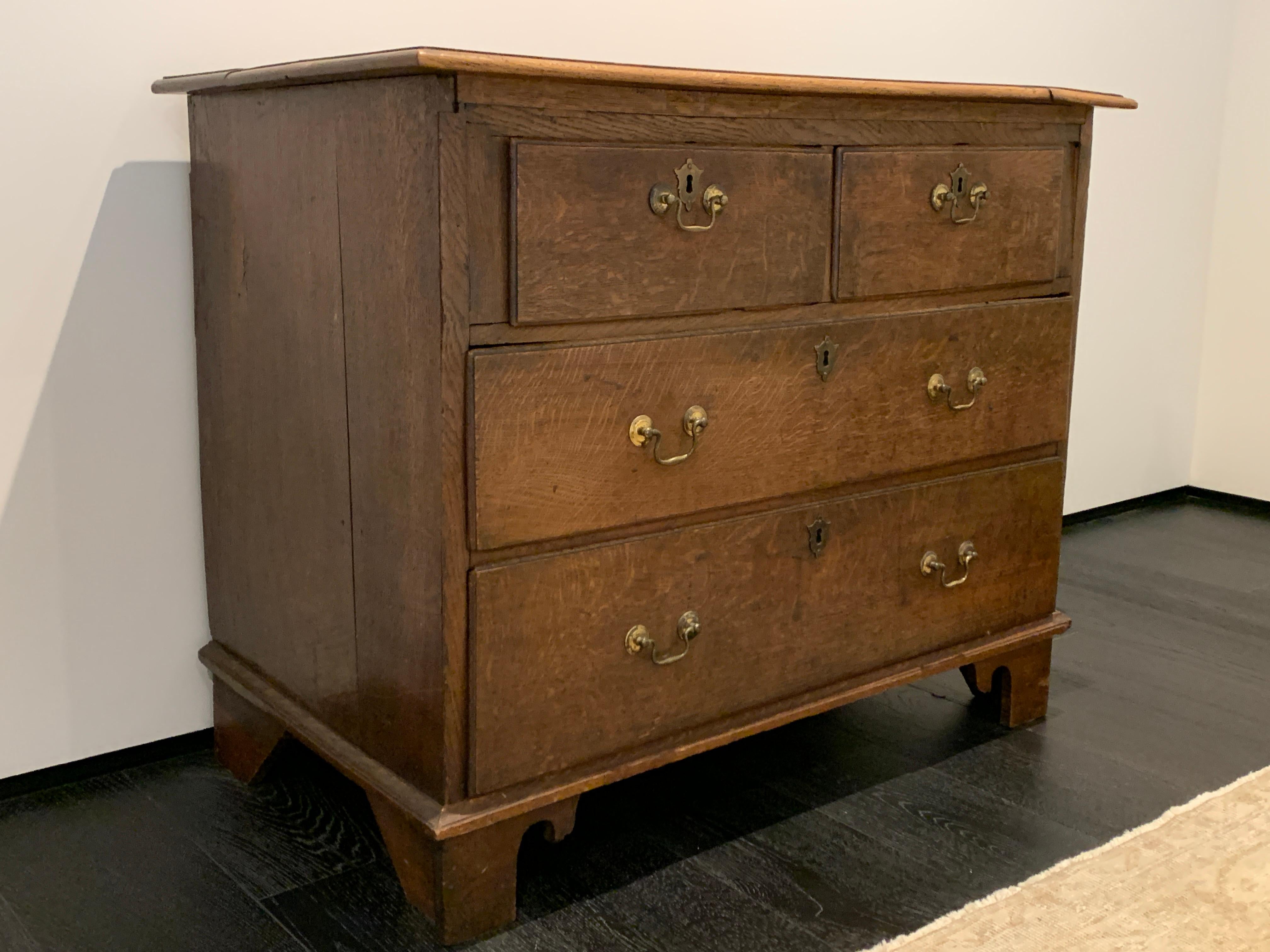 19th century chest of drawers with brass hardware and original finish. Very attractive as side table or dresser with medium brown oak finish.