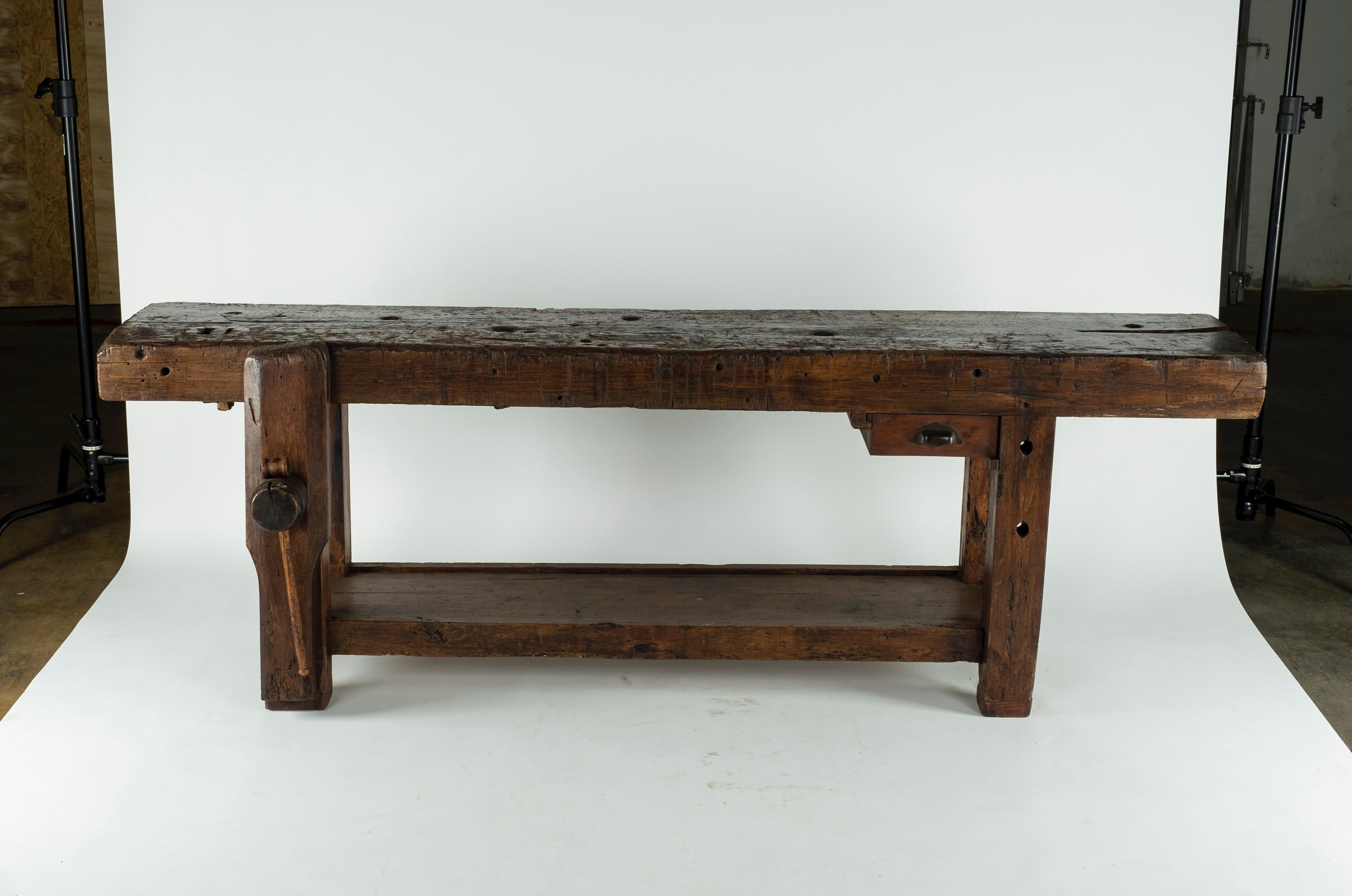 19th century chestnut workbench with original vise and a shelf underneath. The depth of the piece with the vise is 24