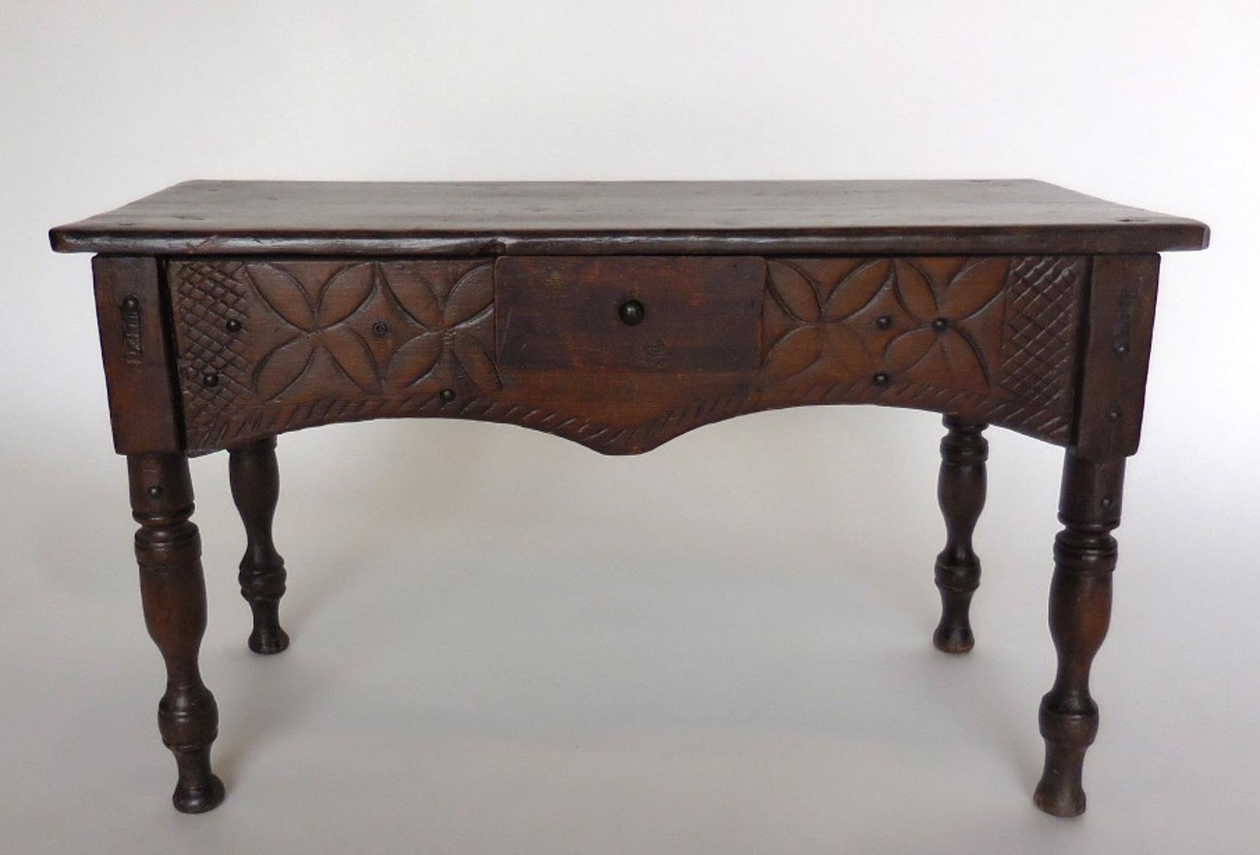 Carved tropical wood child's table with carvings and small drawer. Original nails, turned legs and a beautiful naturally aged patina throughout. Carvings have been smoothed down through years of wear. Legs are dainty and elegant as is the apron.