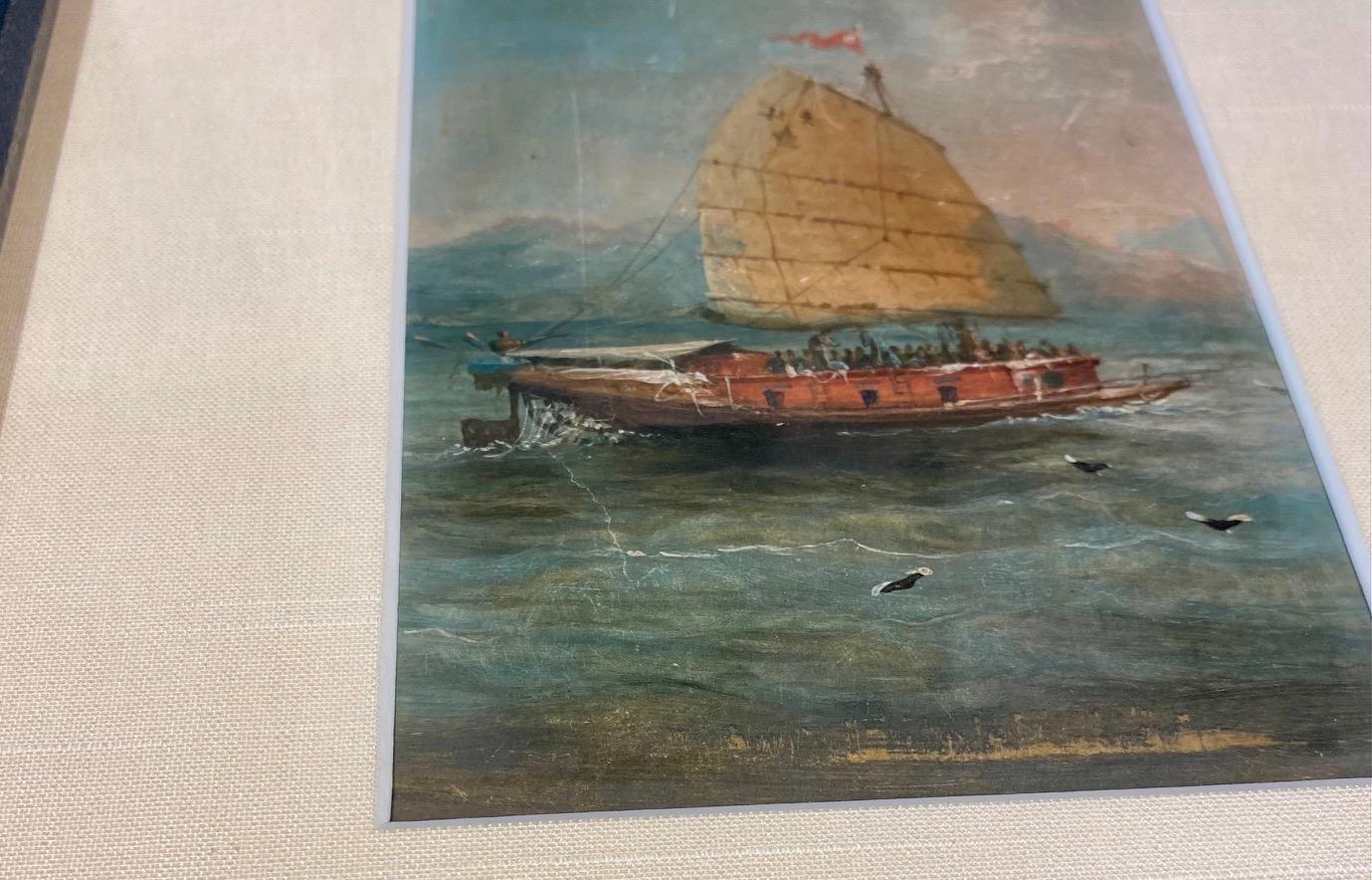 19th century China trade seascape with a Junk, one of three Export paintings, circa 1830s, a small finely detailed oil on panel seascape with junk under sail, red pennant flying from mast, calligraphy on lateen sail, crew visible on deck, seabirds