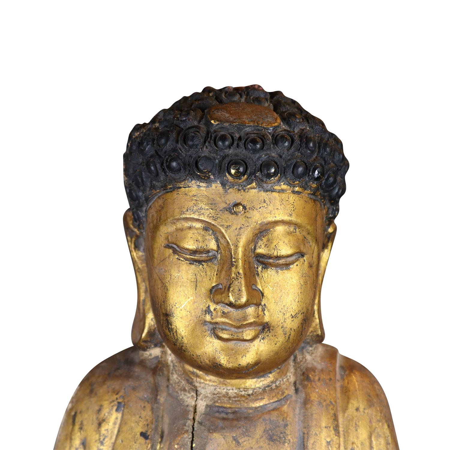 Eine große, antike chinesische Figur des Medizinbuddhas Bhaishajyaguru aus handgefertigtem, vergoldetem, teilweise lackiertem Tropenholz, in gutem Zustand. Die Skulptur ist in ein bodenlanges Gewand gekleidet, das auf der Brust ein Hakenkreuzsymbol