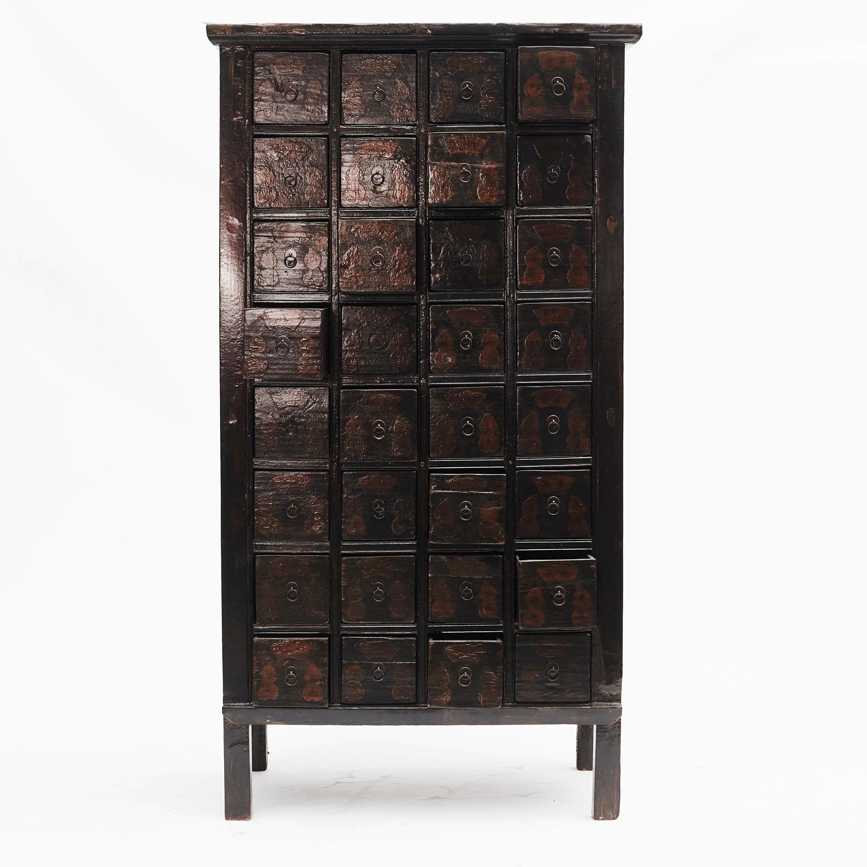 Beautiful Chinese apothecary medicine cabinet dating to circa 1840 from the Shanxi province, China. 
32 drawers with remains of the descriptions with the name of different medicinal herbs.
Original black lacquer. Signs of wear and tear that come