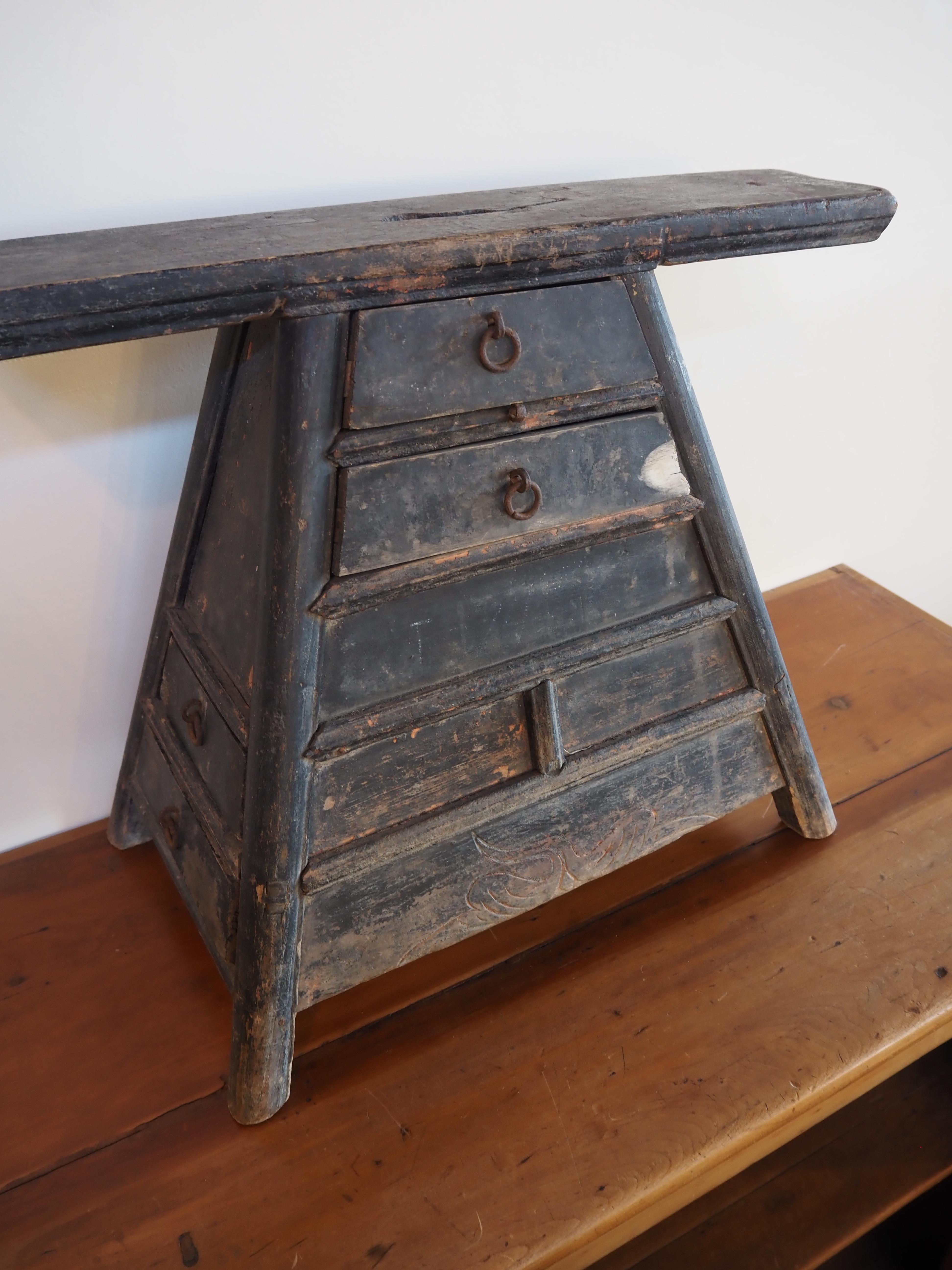 19th century Chinese barber stool in beautiful grey-blue. Hand carved detailing reminiscent of time and origin. Well-worn patina adds depth to every angle of this sculptural piece.

Two small drawers in the front and two small drawers on the side.