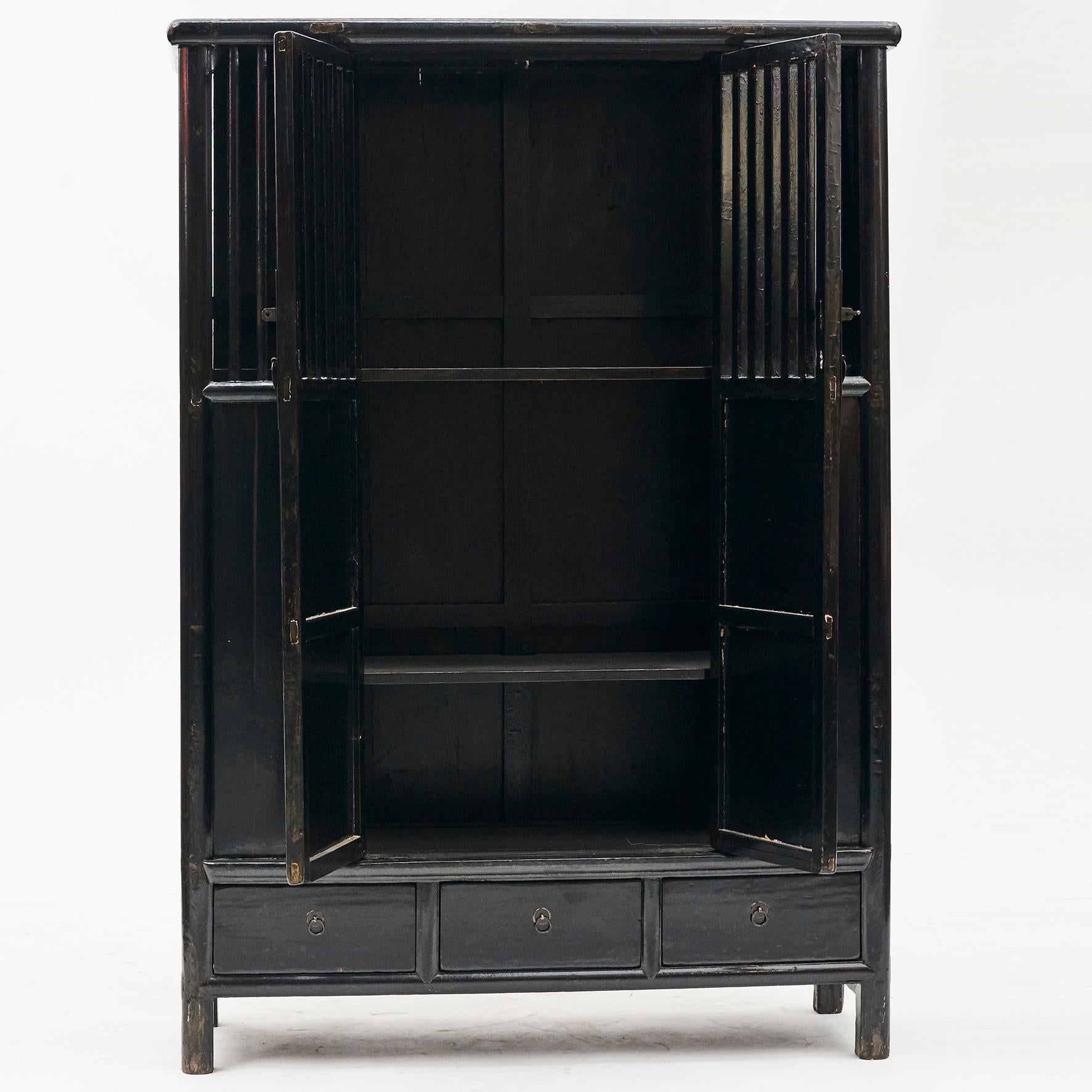 2 door lattice door cabinet from Jiangsu, China, circa 1820-1830.
Pair of doors. The inside has a large three shelf storage area and three drawers at the bottom fitted with brass drawer pulls.
Original condition and black lacquer with natural
