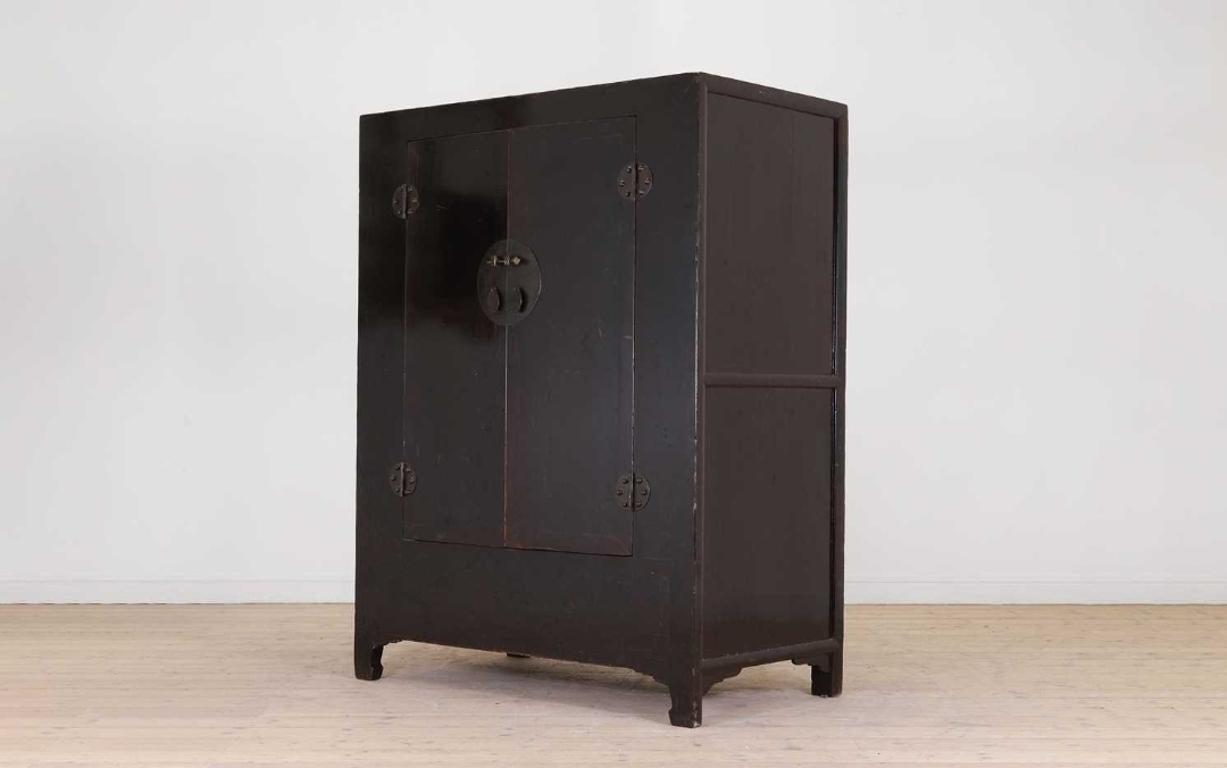 A rare Ming design, lacquered Elm cabinet dating back to the early 19th century is offered for sale. This exquisite cabinet boasts a beautiful minimalist design that will suit both modern and more traditional interiors. It features a wonderful