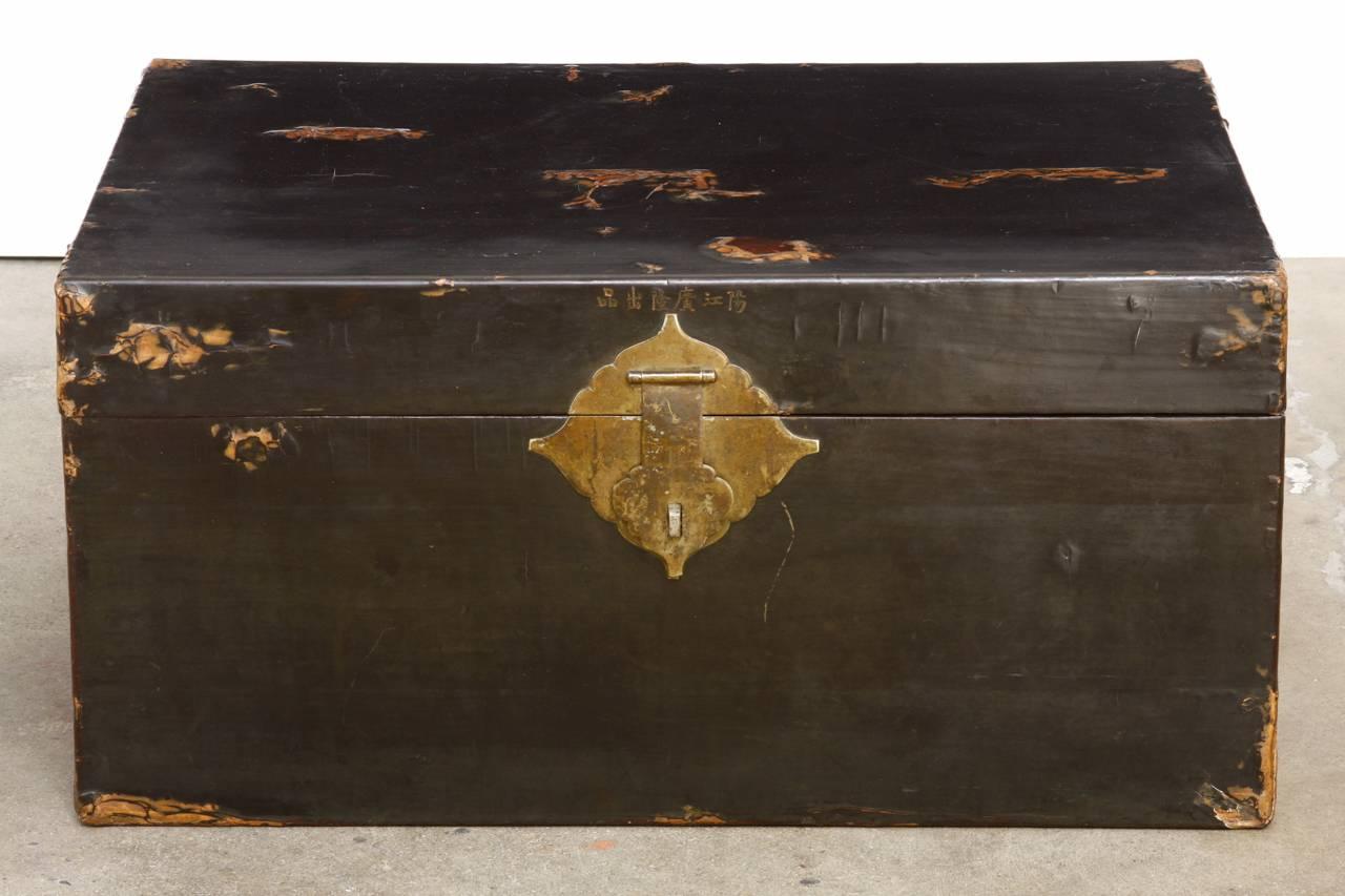 Rare 19th century Chinese pigskin trunk featuring a black lacquered finish. Beautiful distressed patina with a smooth soft finish. Brass-mounted large handles, hinges, and lock plate with original working key. Maker's mark on the inside and Chinese