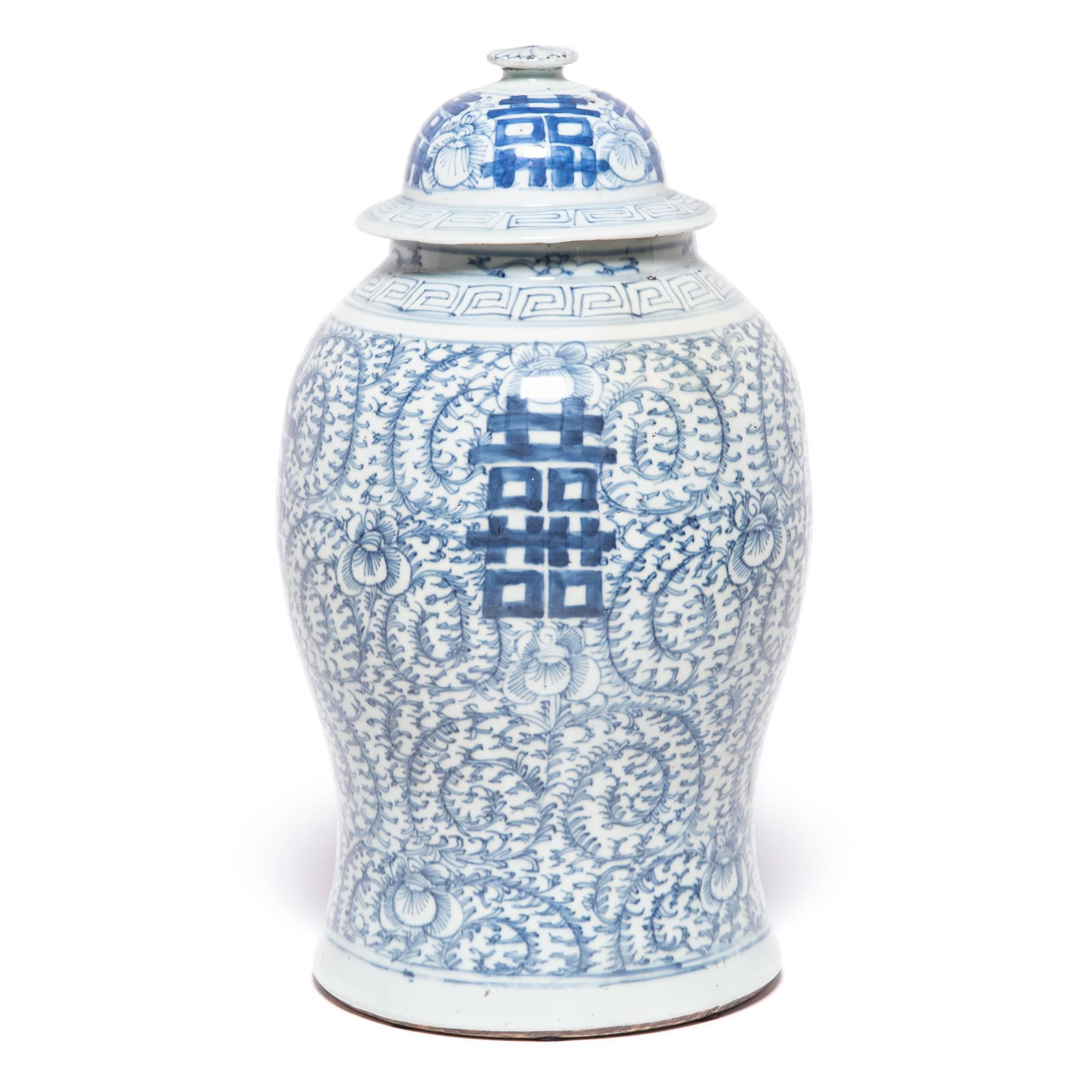 This blue and white ginger jar, which was originally intended for storing spices, is hand painted with trailing vines and the character for 