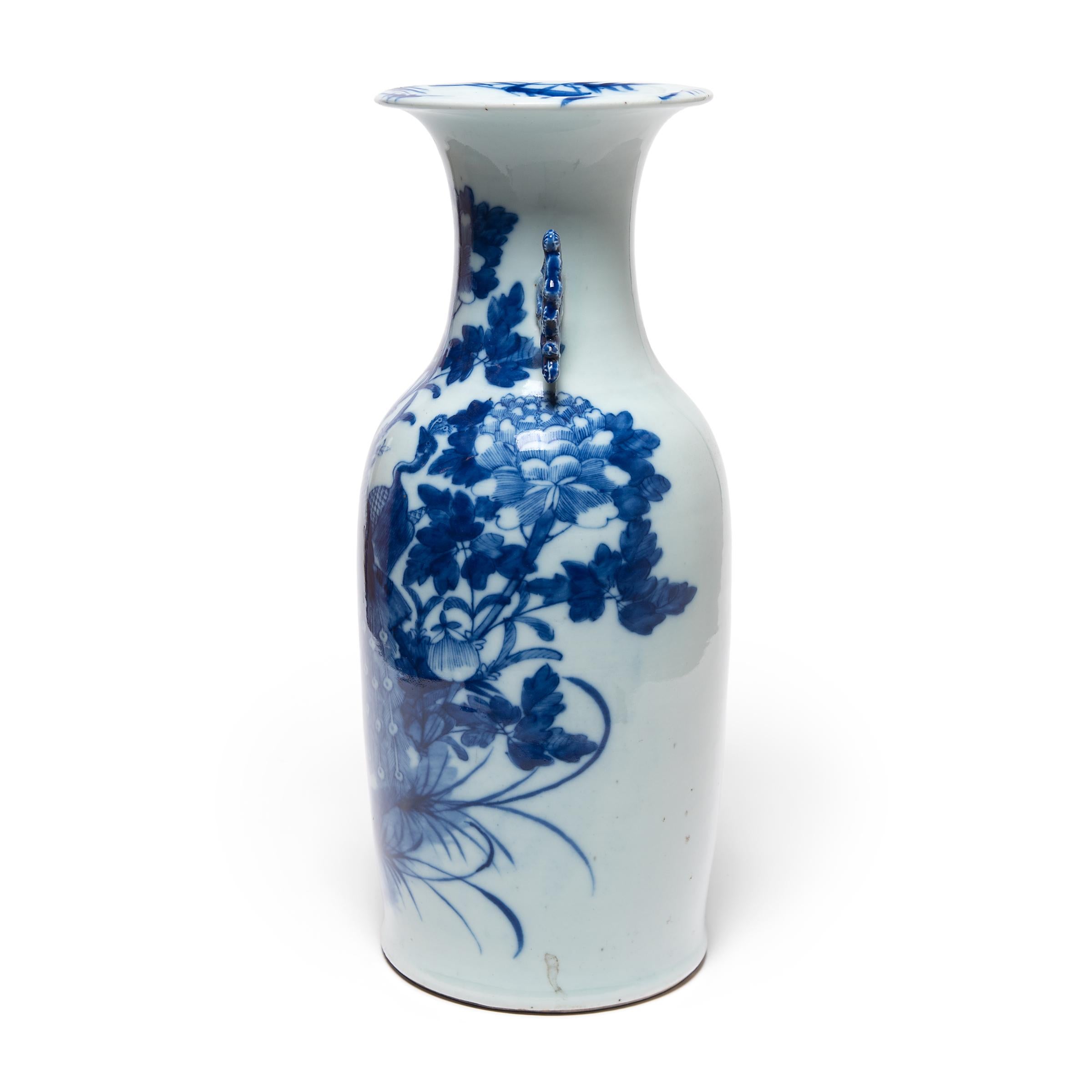 This 20th-century porcelain vase is an exquisite example of Chinese blue-and-white pottery. The vase is expertly formed with thin walls, widening to a flared lip and flanked by two molded scroll handles. Painted with richly saturated cobalt