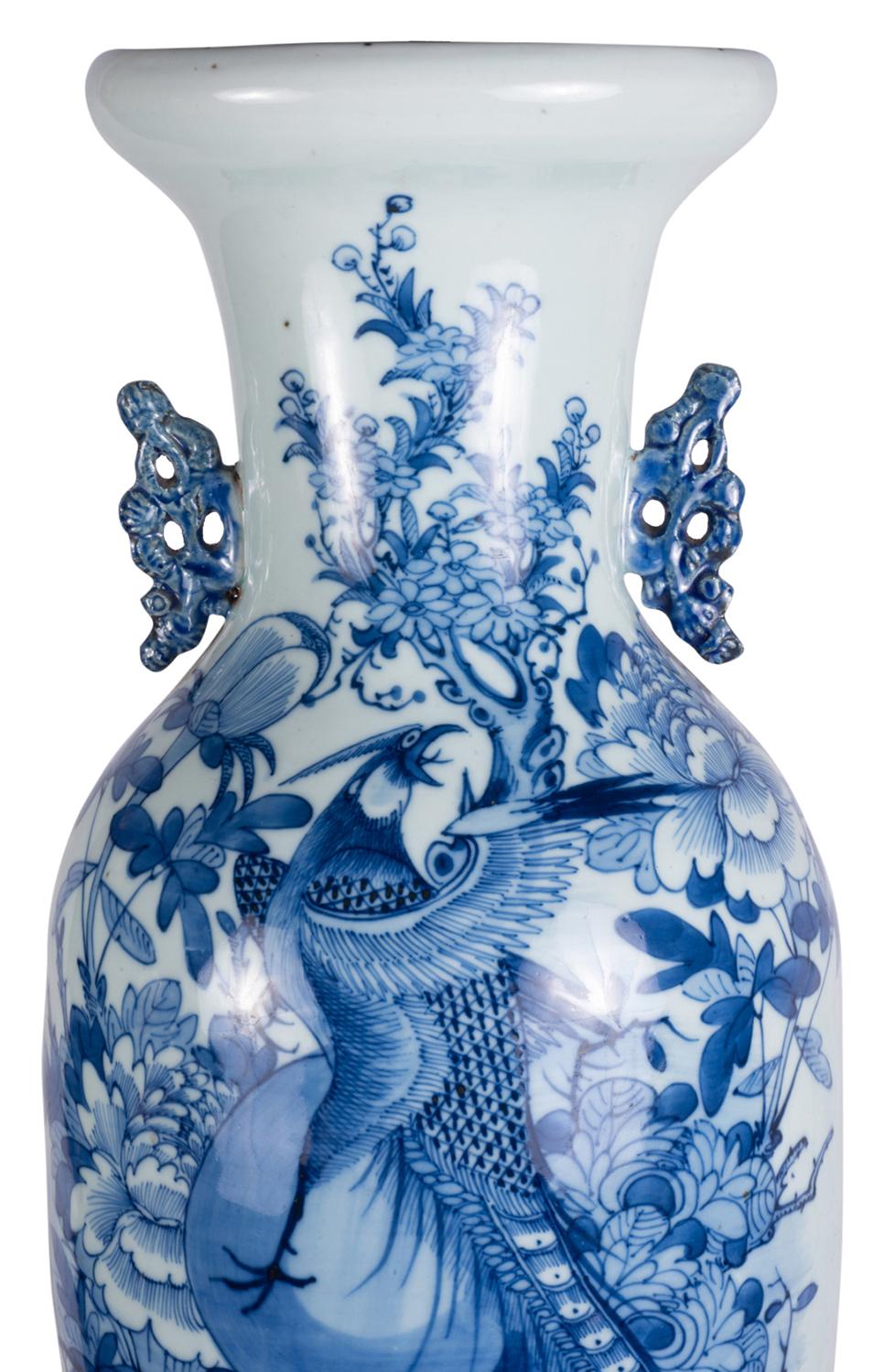 Un vase ou une lampe très décoratif du 19ème siècle en bleu et blanc, avec un fond blanc avec des scènes peintes à la main en bleu d'oiseaux exotiques, de fleurs et de feuillage, des poignées en porcelaine percées de chaque côté et une base en bois.