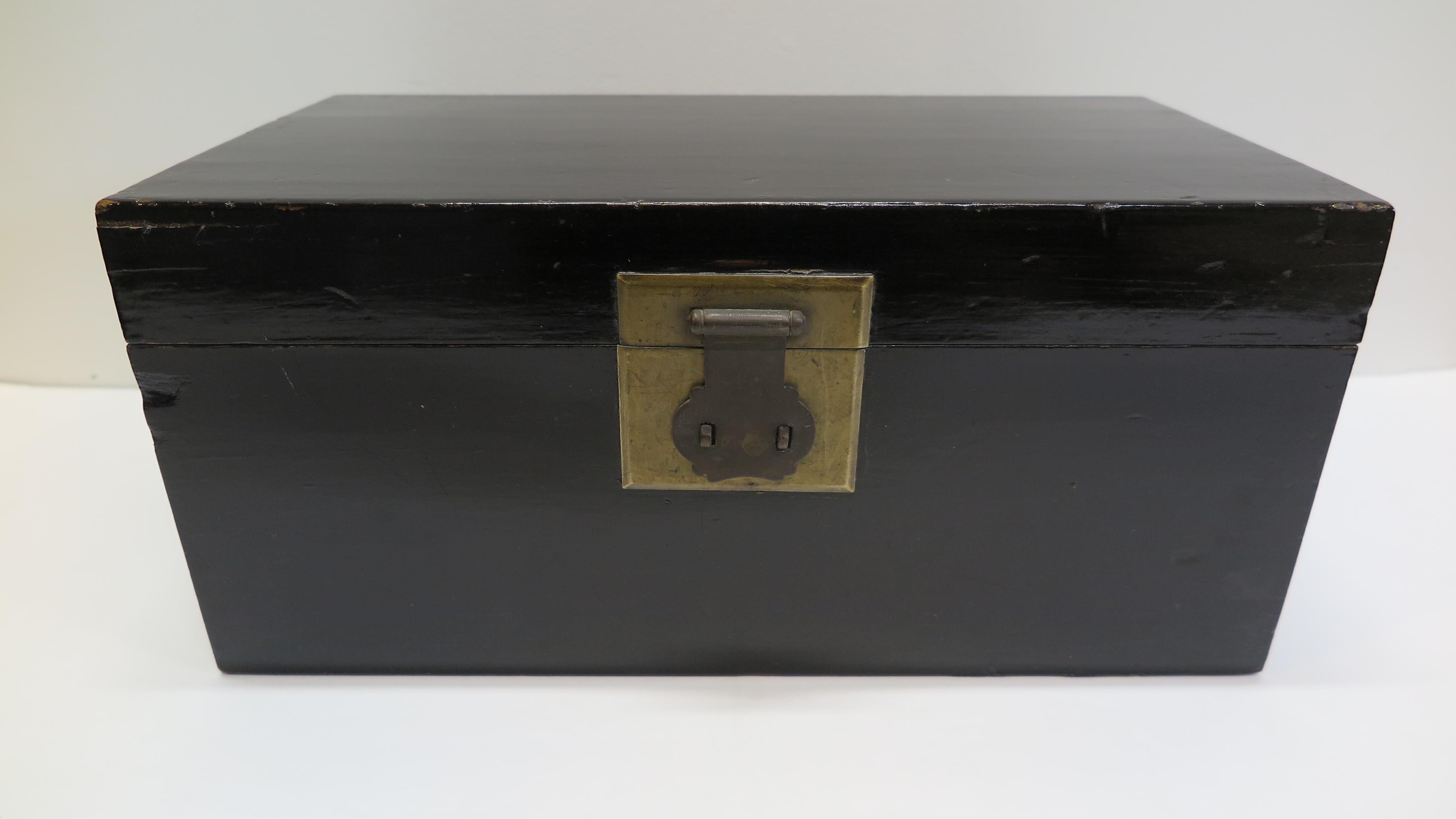 19th century Chinese black lacquered comfort box. Classic Chinese comfort box in black lacquer with top shelf lower compartment having bronze badge hardware and handles with bumpers on each side. Used for personal objects such as jewelry. Nicely