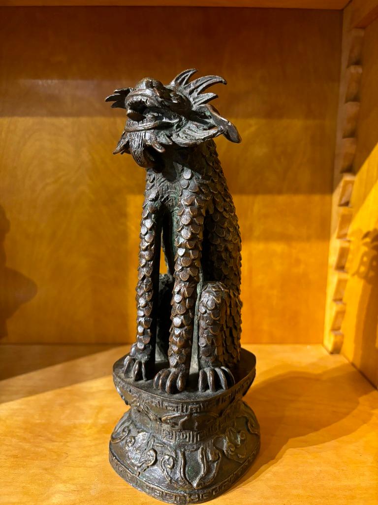 Chimera di bronzo seduta del XIX secolo, o forse precedente, fusa come una feroce bestia squamata seduta in posizione di difesa con la testa rivolta in avanti mentre apre la bocca in un ruggito esponendo la lingua e le orecchie mostrate tra le corna