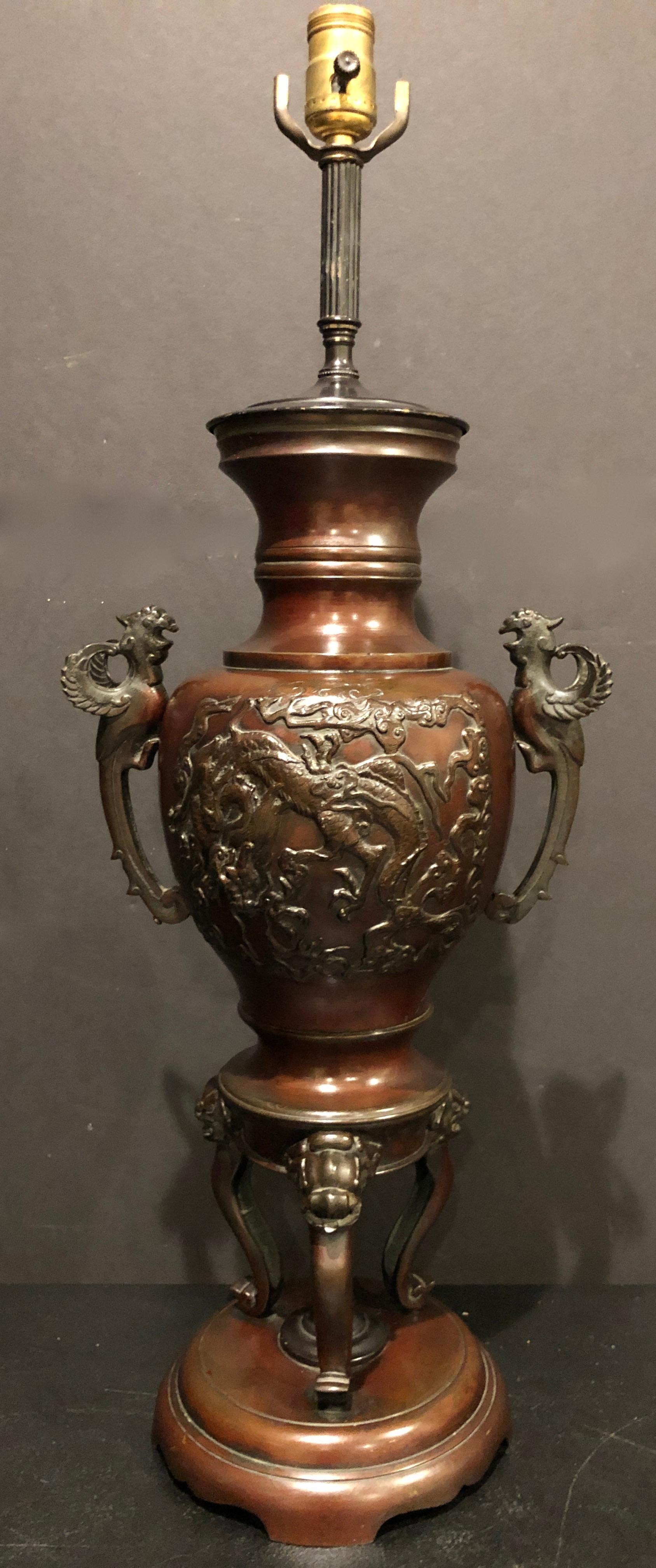 19th century Chinese bronze urn as lamp. Decorated with florals and dragon in high relief. Surmounted by two handles depicting phoenix birds.
Measures: 22