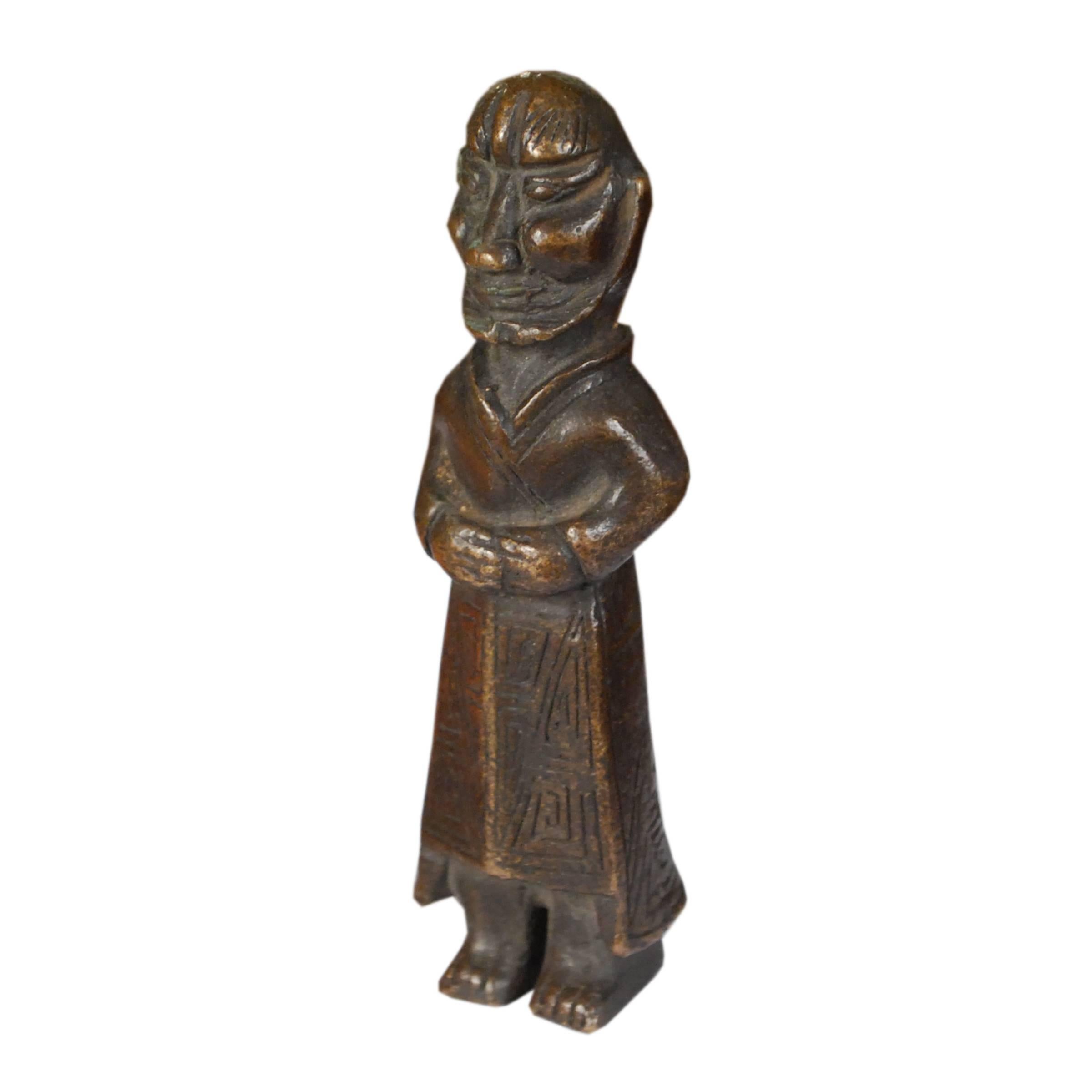 Meant to be tucked into a pocket as a charm, this tiny figure of a wise elder was kept close in hand as a talisman for wisdom, good luck, and protection. Cast of bronze in Shanxi province in the mid-19th century, this charm has gained a lovely