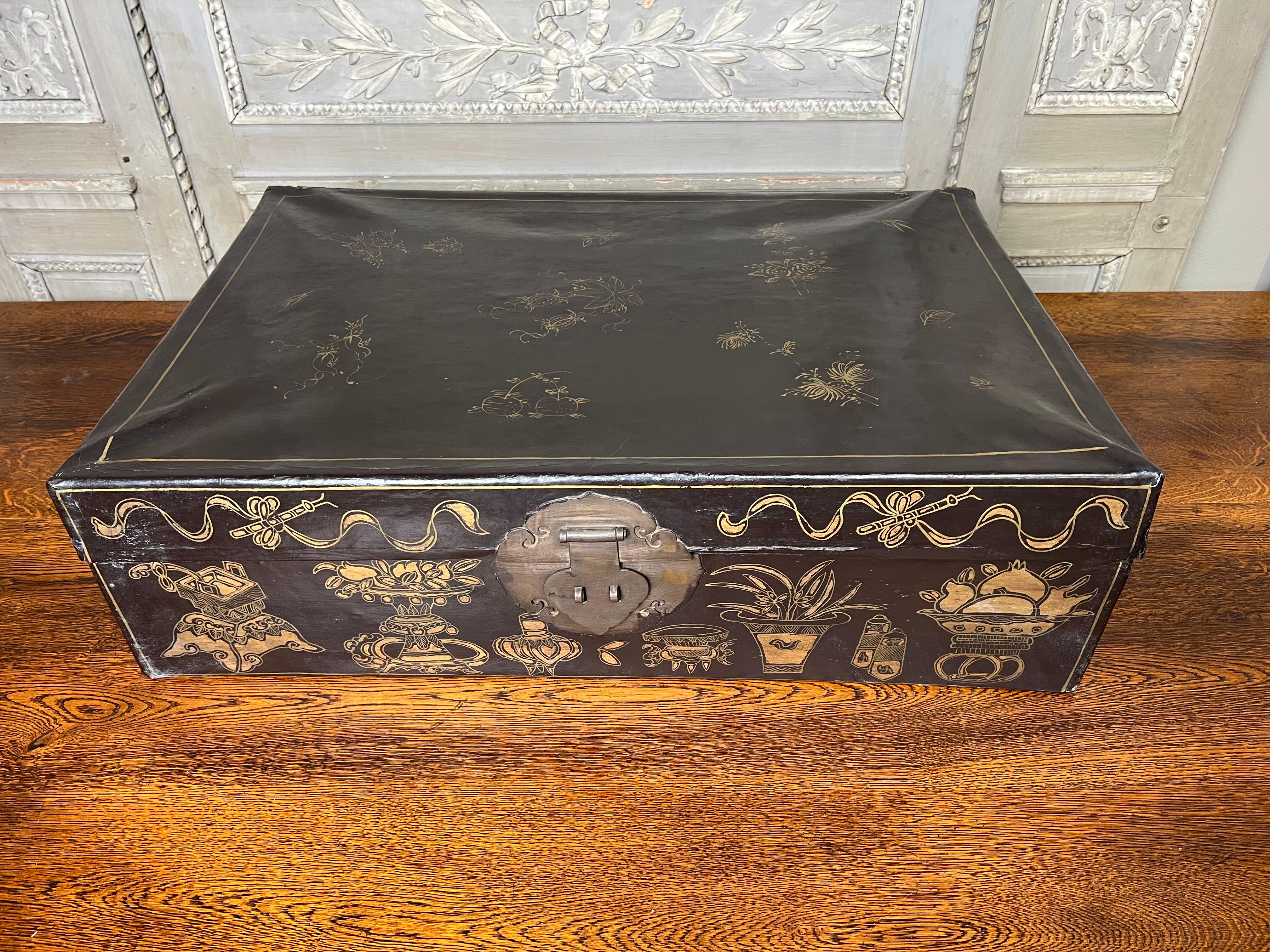 A 19th century Chinese brown and gilt leather trunk with an oxblood red lacquered interior.  This trunk is a smaller scale and is a perfect home accent being small enough to fit on a large coffee table, under a console etc.  
It it very decorative