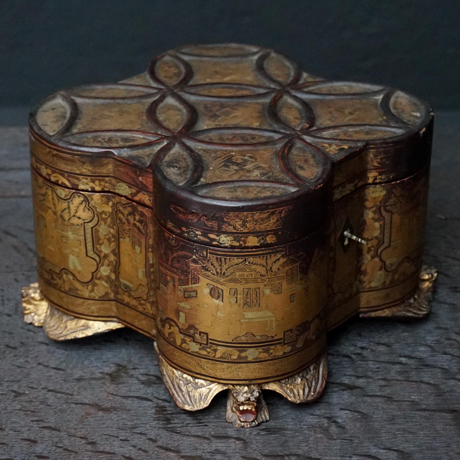 Clover or quartreform shaped mid-19th century Chinese canton export tea caddy in gold lacquered wood on a black background.
Decorated with palace scenes animated with figures engaged in various pursuits within walled gardens.
Interior with pewter