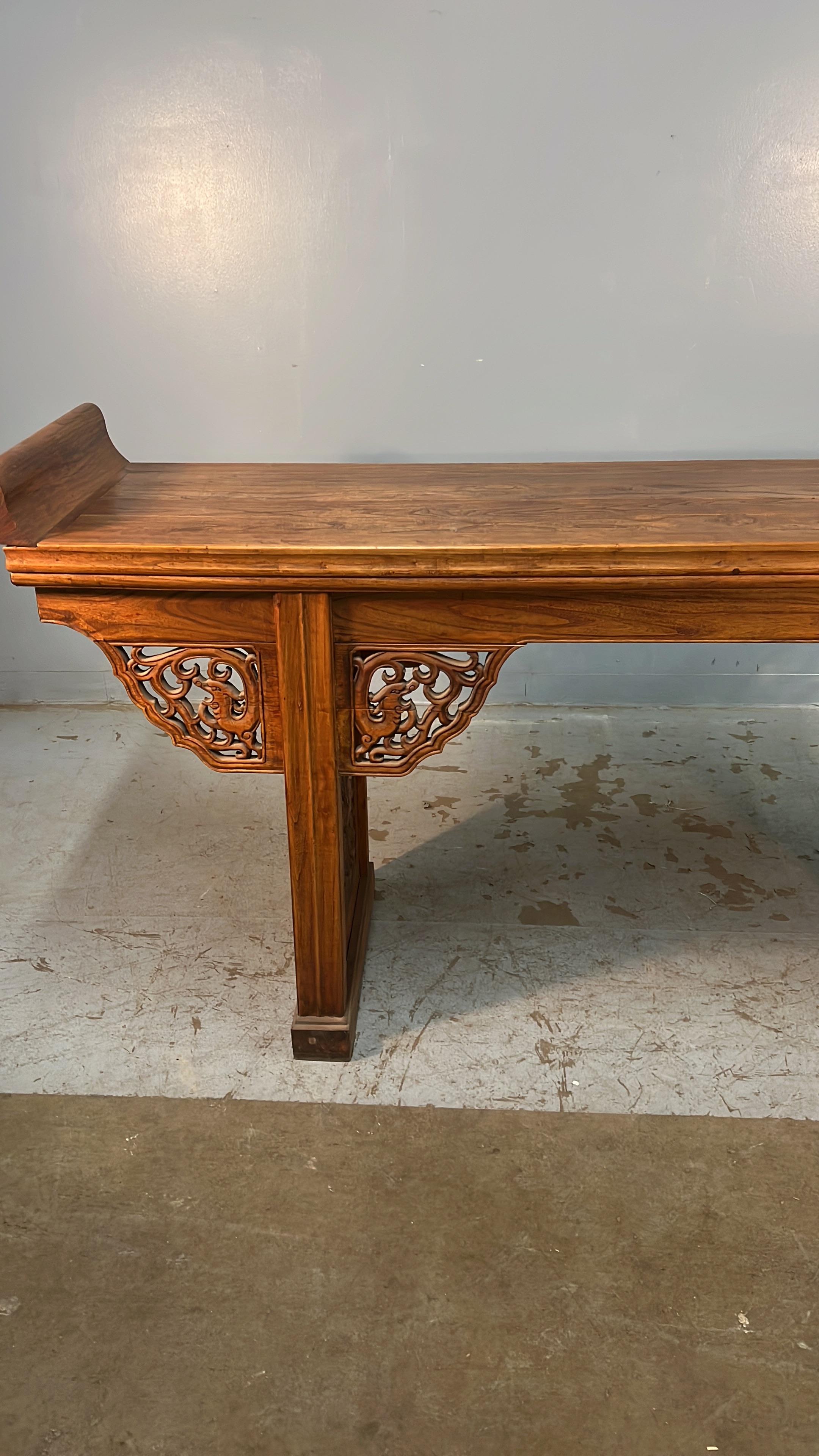 Ein chinesischer Altartisch des 19. Jahrhunderts aus stark geschnitztem Ulmenholz.  
Dieser Tisch eignet sich hervorragend als Serviertisch oder als Konsolentisch.  Er ist sehr dekorativ und hat eine lange, schmale Form.  