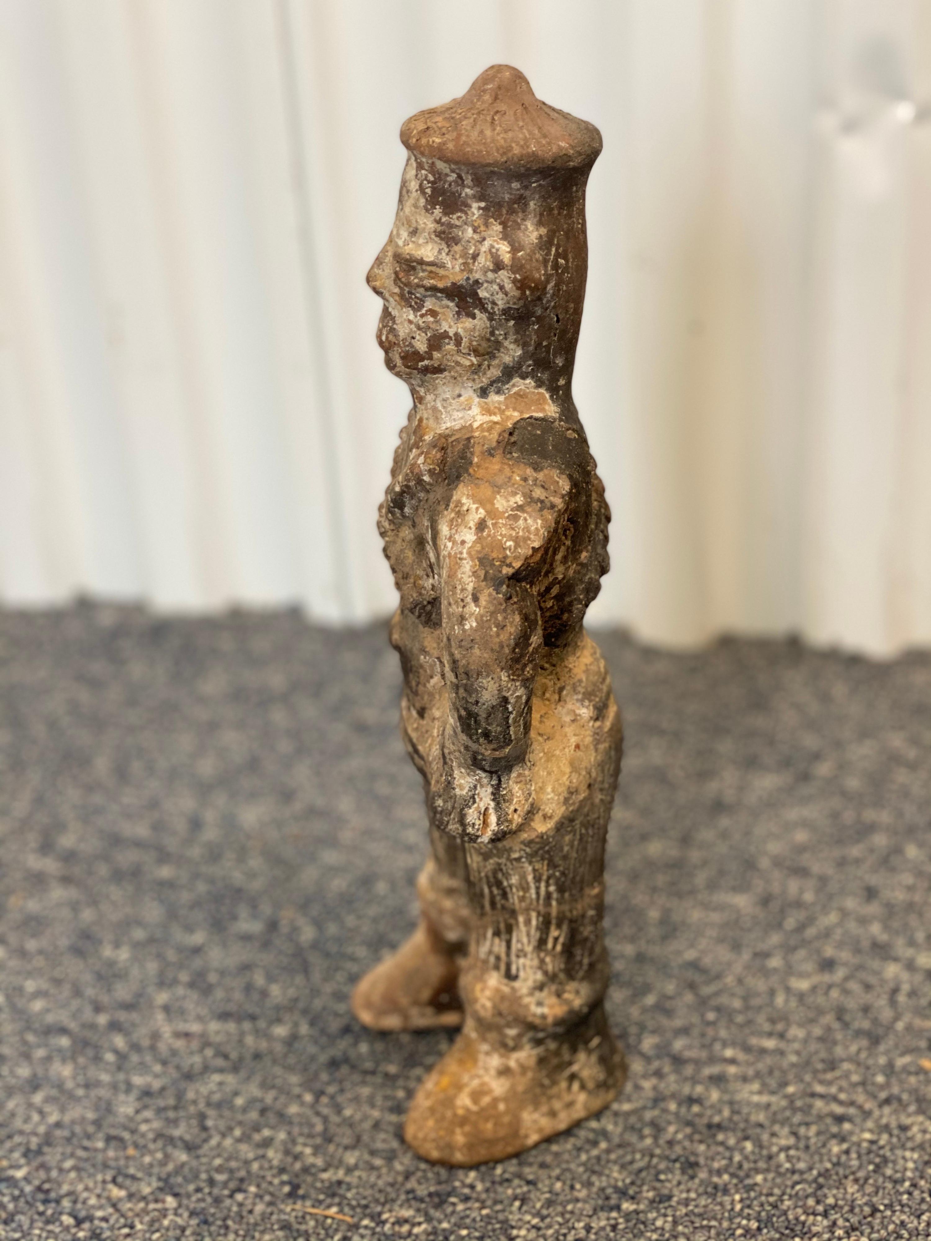 19th century Chinese carved figure. While this sculpture may be small it isn't lacking in its attention to detail.
Across the chest of the figure you cans see two overlapping carved out slings or belts that drape both the front and back in an