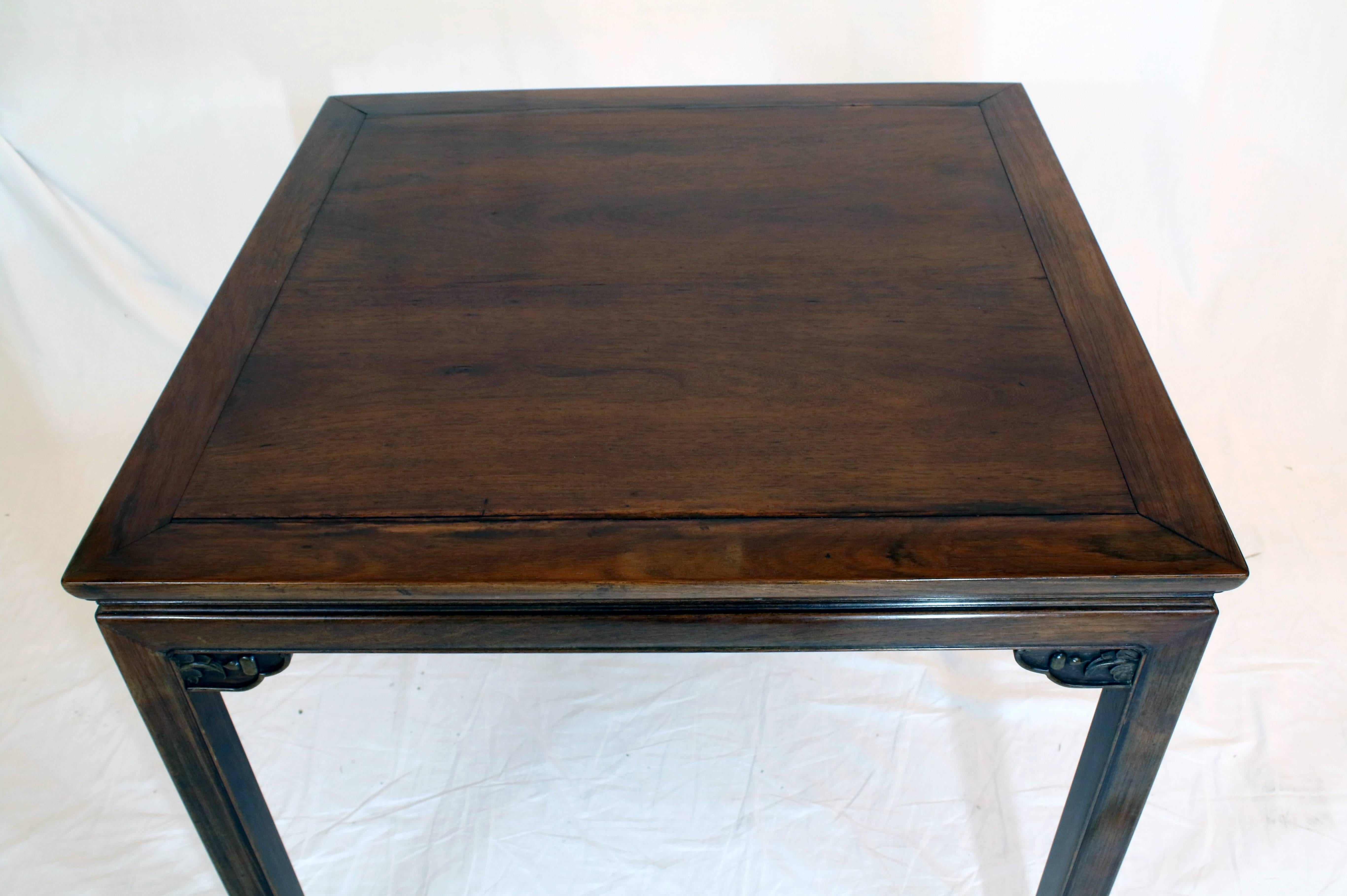 19th century game/mahjong table made from namu wood features a highly polished square top surface with hand-carved brackets which brace four minimal Marlborough legs that terminate in an Oriental scroll. The table is handcrafted and structured with