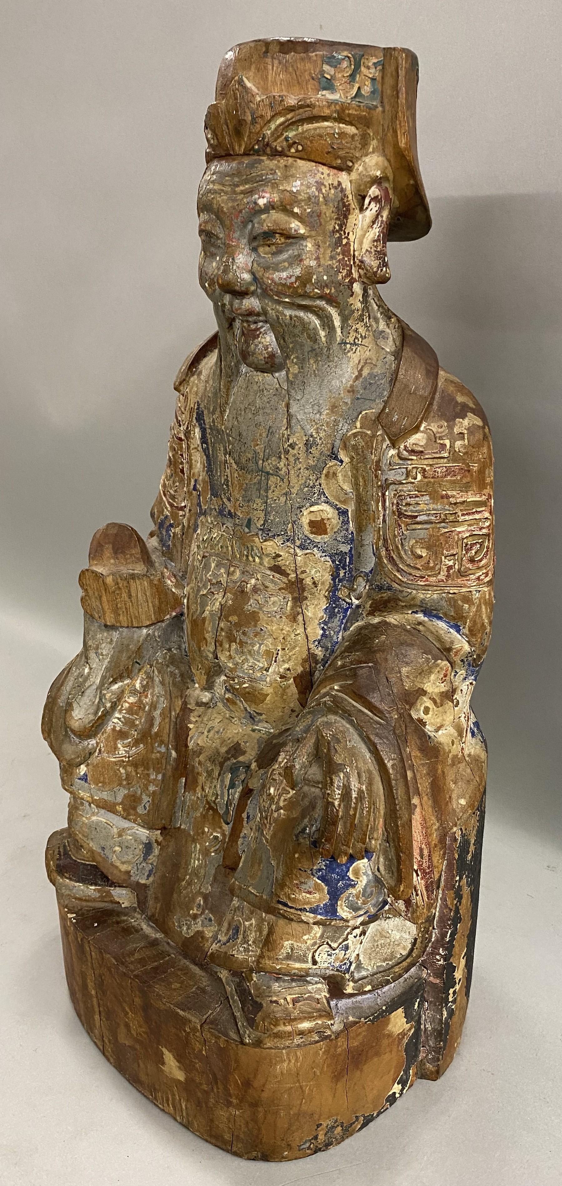 A fine hand carved polychrome wooden seated Chinese ancestral figure sculpture, dating to the 19th century, with deep back cutouts, some paint losses, shrinkage cracks, edge losses, and wear commensurate with age and use. Dimensions: Approximately