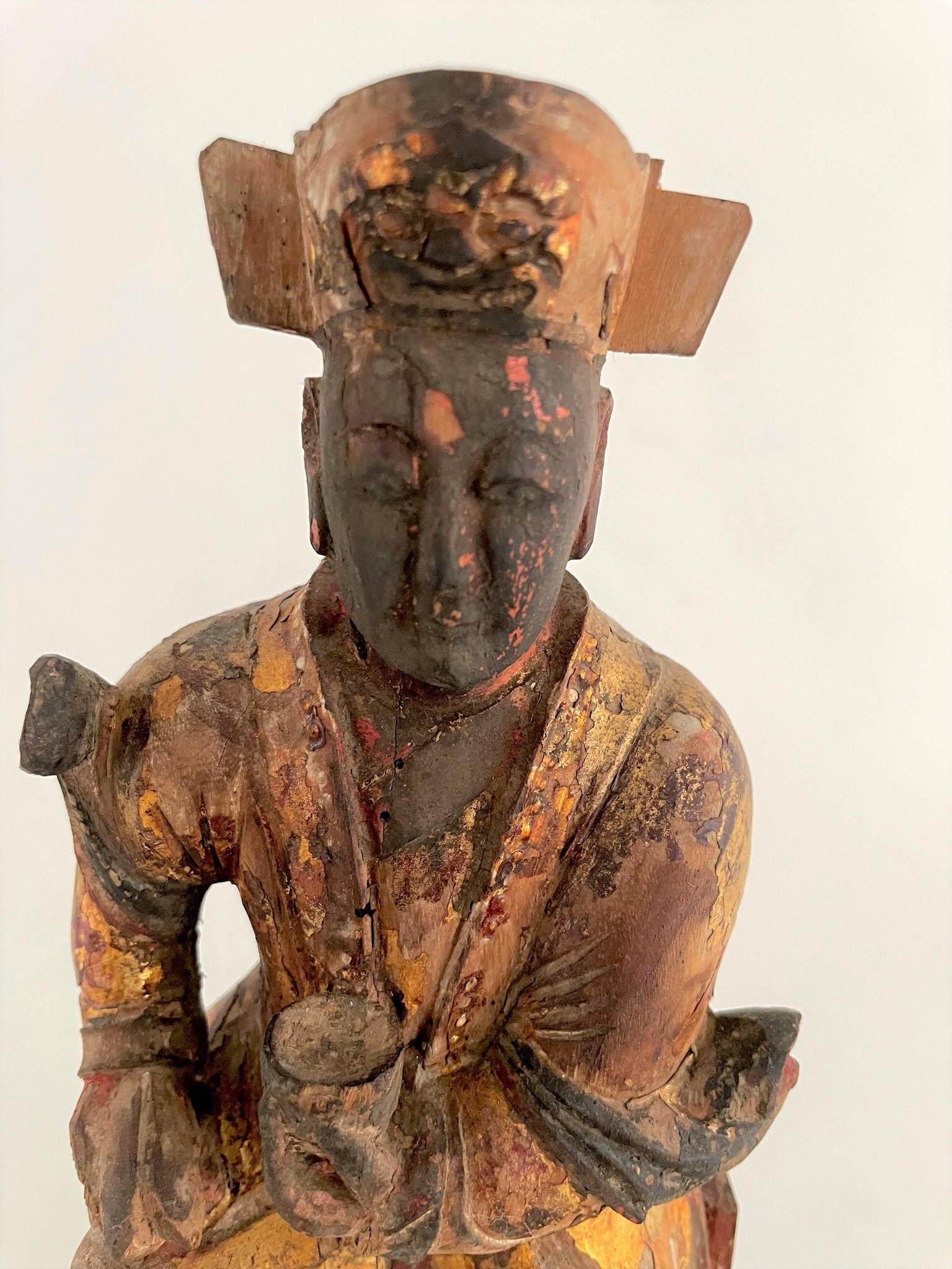 This Chinese carved seated altar god was once used on the family altar to honor their ancestors.  Ancestor worship plays a major role in Chinese religion. This beautifully carved figure is rich with character from a century of use with wonder signs