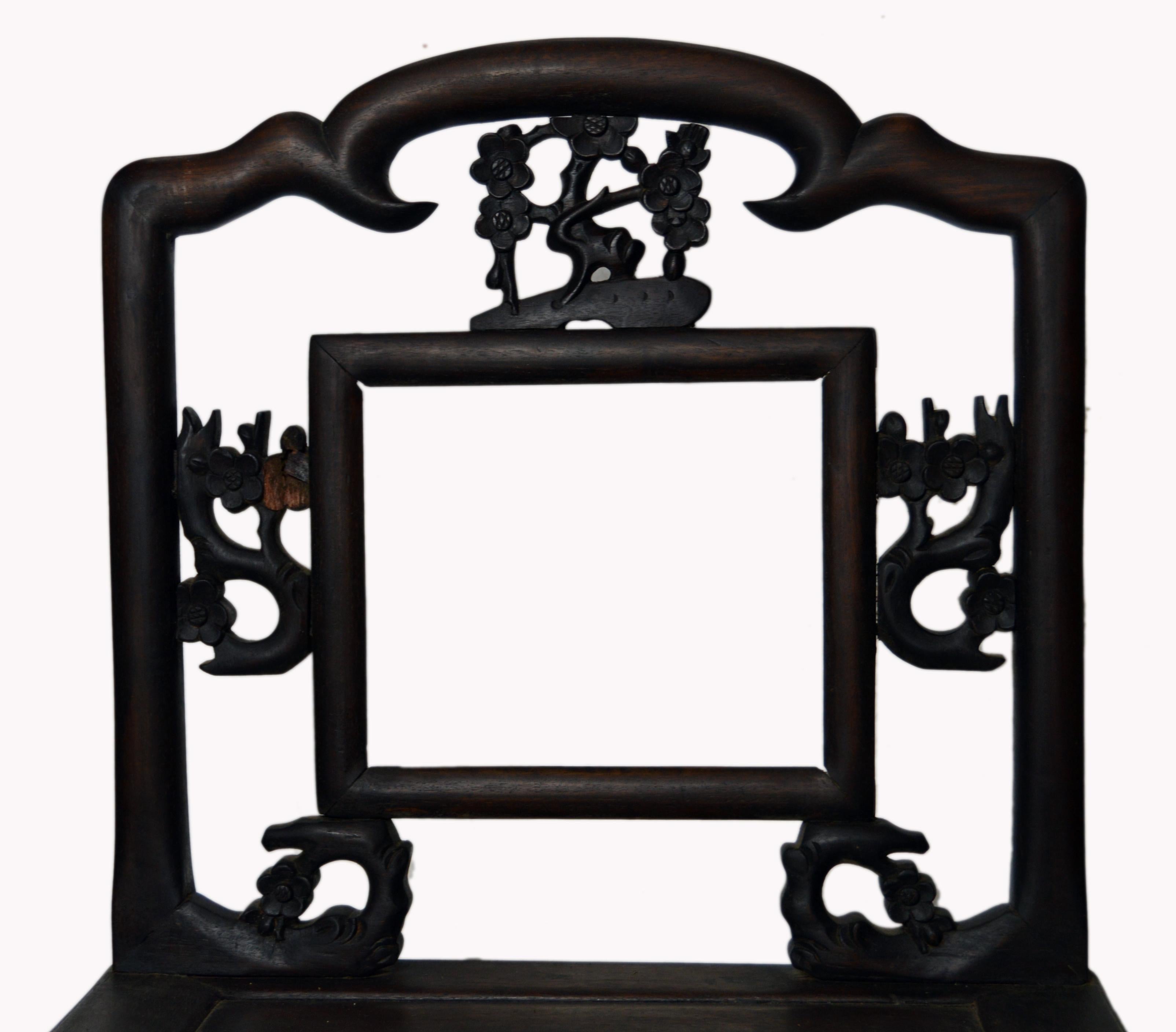 A Chinese 19th century hand-carved wooden chair with cherry blossom fretwork and dark lacquer finish. This handmade wooden chair features a rectangular seat sustained by a carved skirt and four straight legs reinforced by side stretchers. The