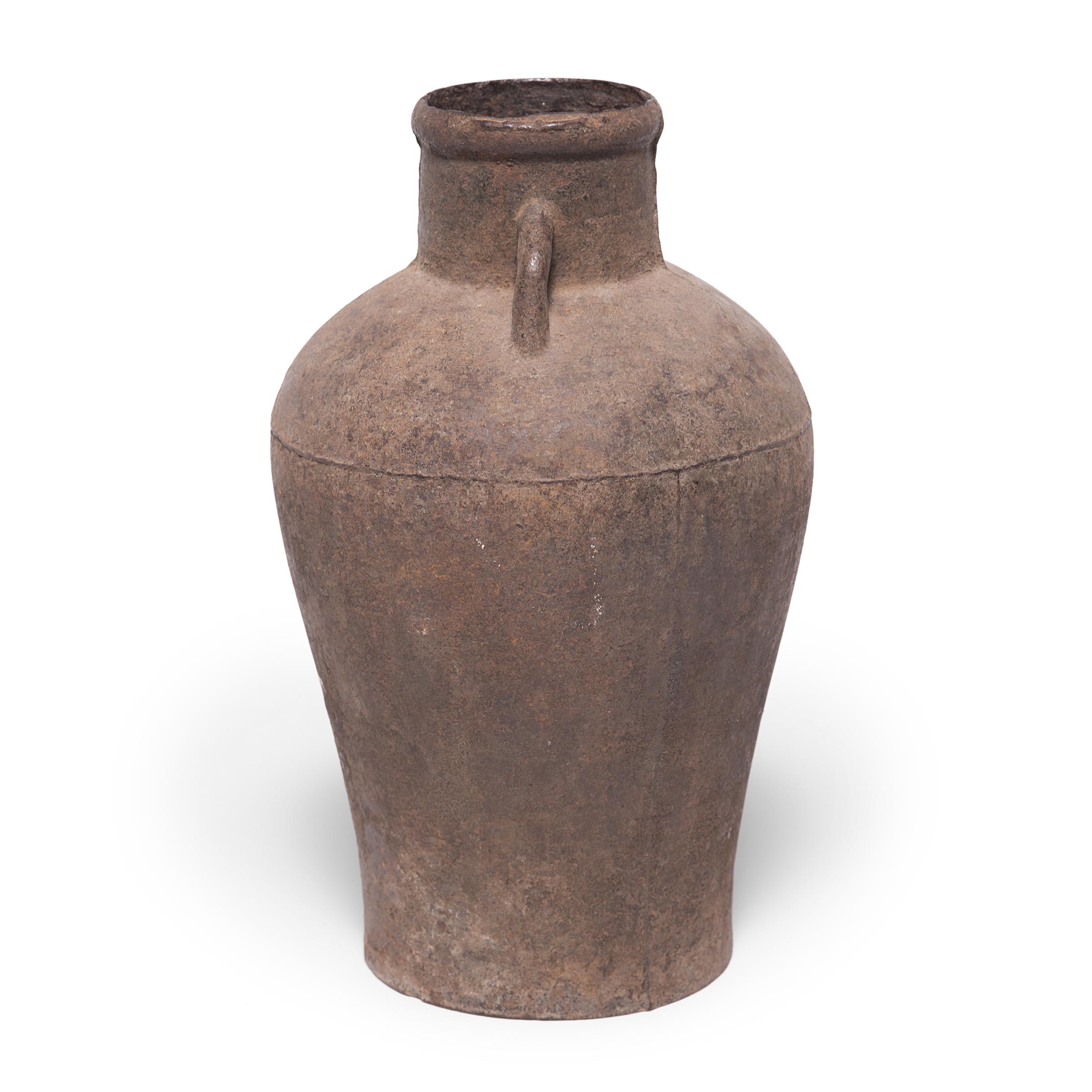 This cast-iron vessel has an elegant form reminiscent of the beautiful ironwork, bronzes, and ceramics perfected by Chinese artisans thousands of years ago. A century ago this jar would have been purely functional, but as the iron has gracefully
