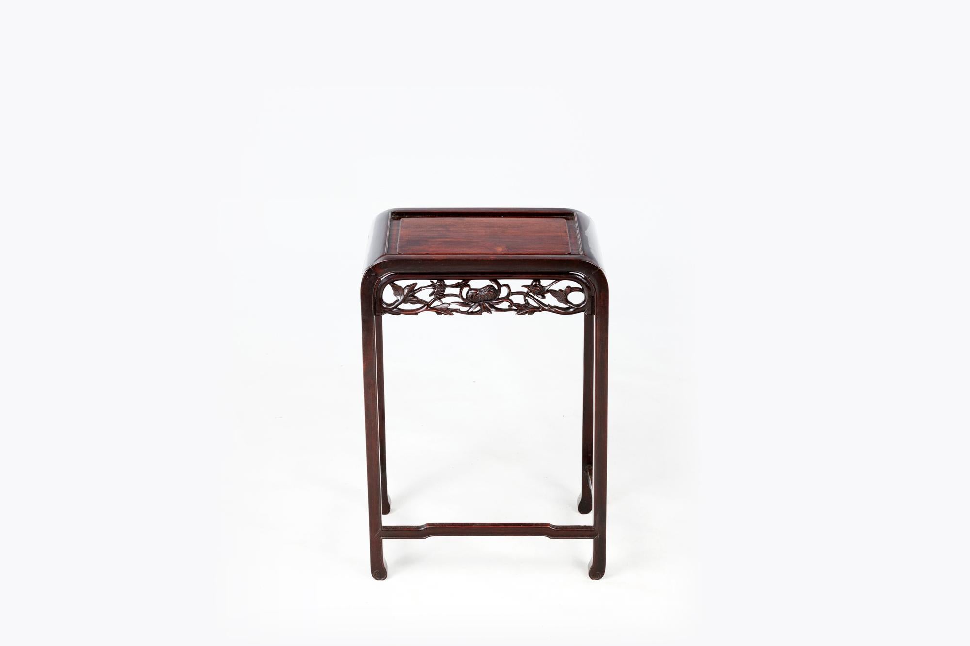 19th Century Chinese Cherrywood occasional table featuring a carved water lily design to apron. With rounded edges, carved divet to top and three delicate stretchers.