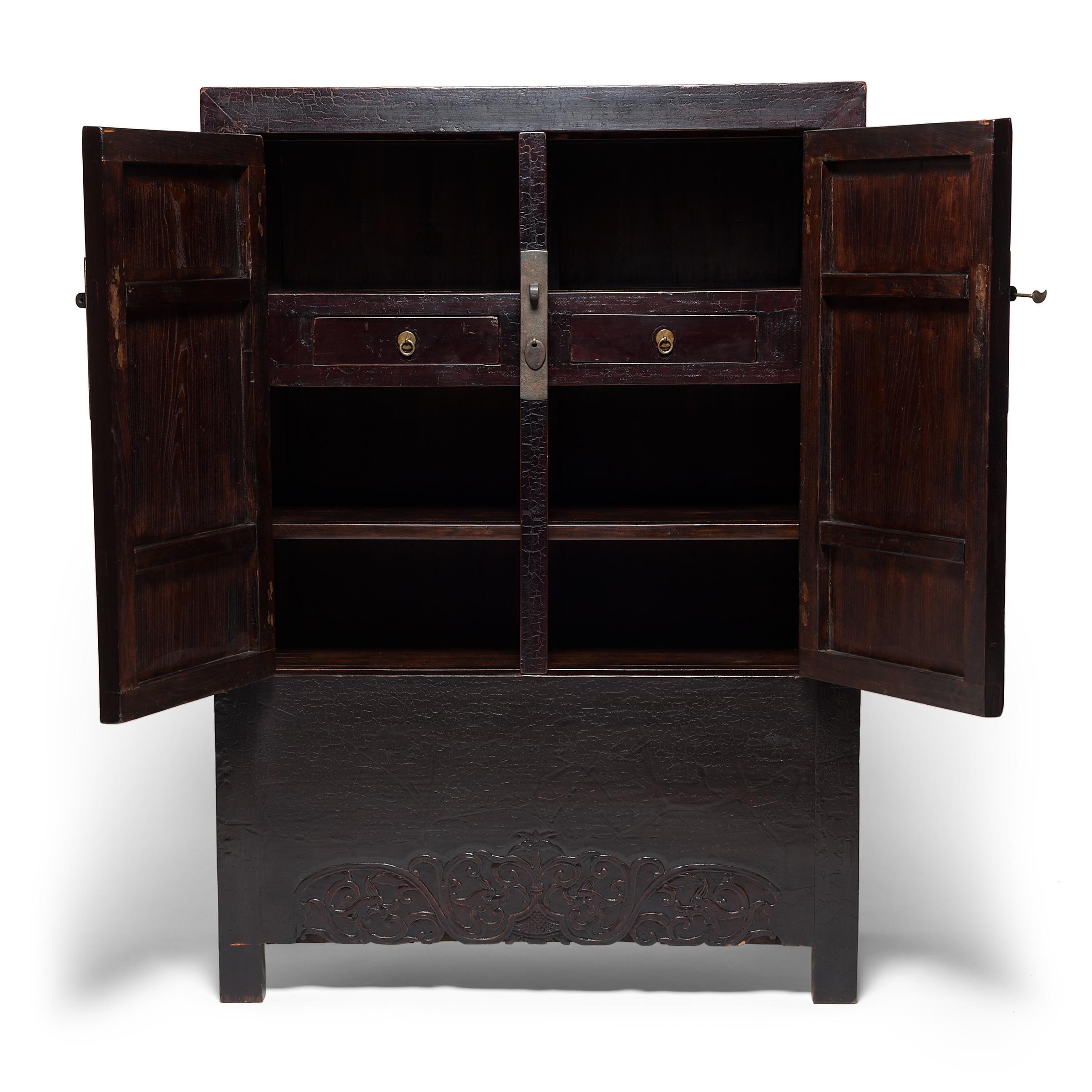 This 19th century cabinet from Shanxi province epitomizes the austerity of classical Chinese furniture design. Bare of ornament aside from its brass hardware, the cabinet's clean lines are contrasted by its subtly carved apron. The intricate