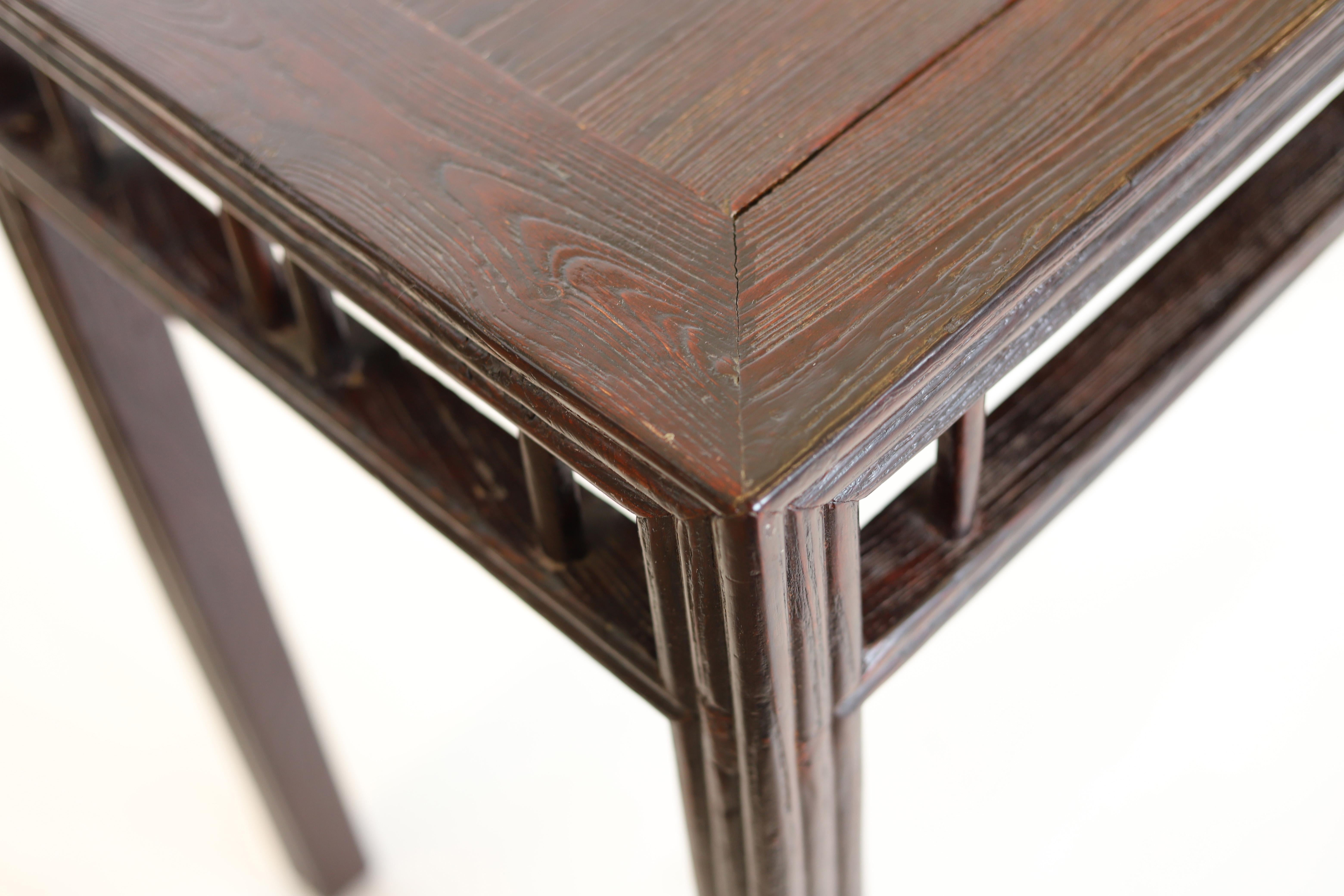 Consola china del siglo XIX de madera oscura (probablemente de olmo).  Esta mesa, utilizada tradicionalmente con fines ceremoniales y como pieza de exposición funcional, presenta un característico tablero largo y estrecho.

El estilo limpio y