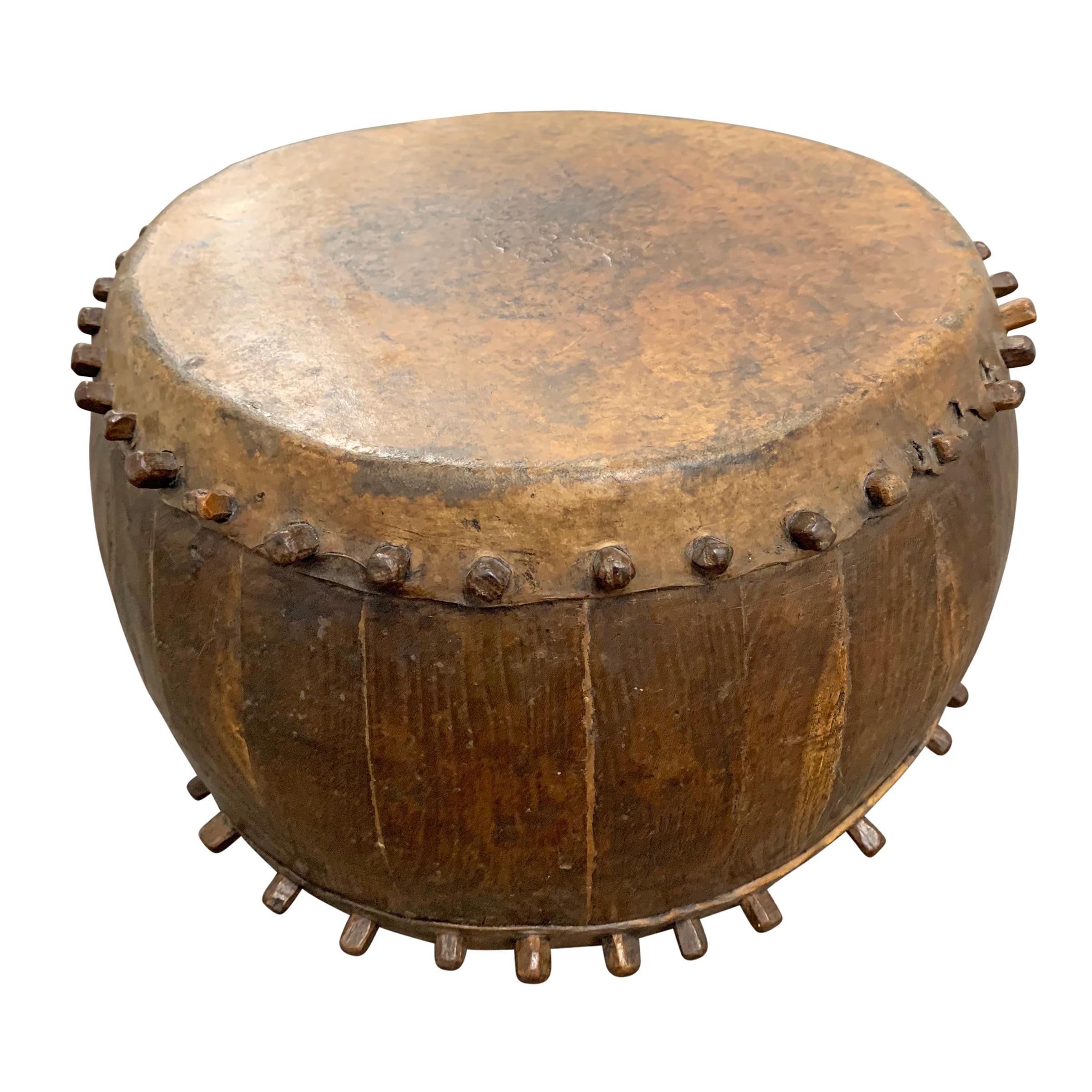 A 19th century Chinese opera drum with stretched hide drumbhead and hand carved wooden pegs to hold it in place. Perfect for use as a small drinks table or side table!
