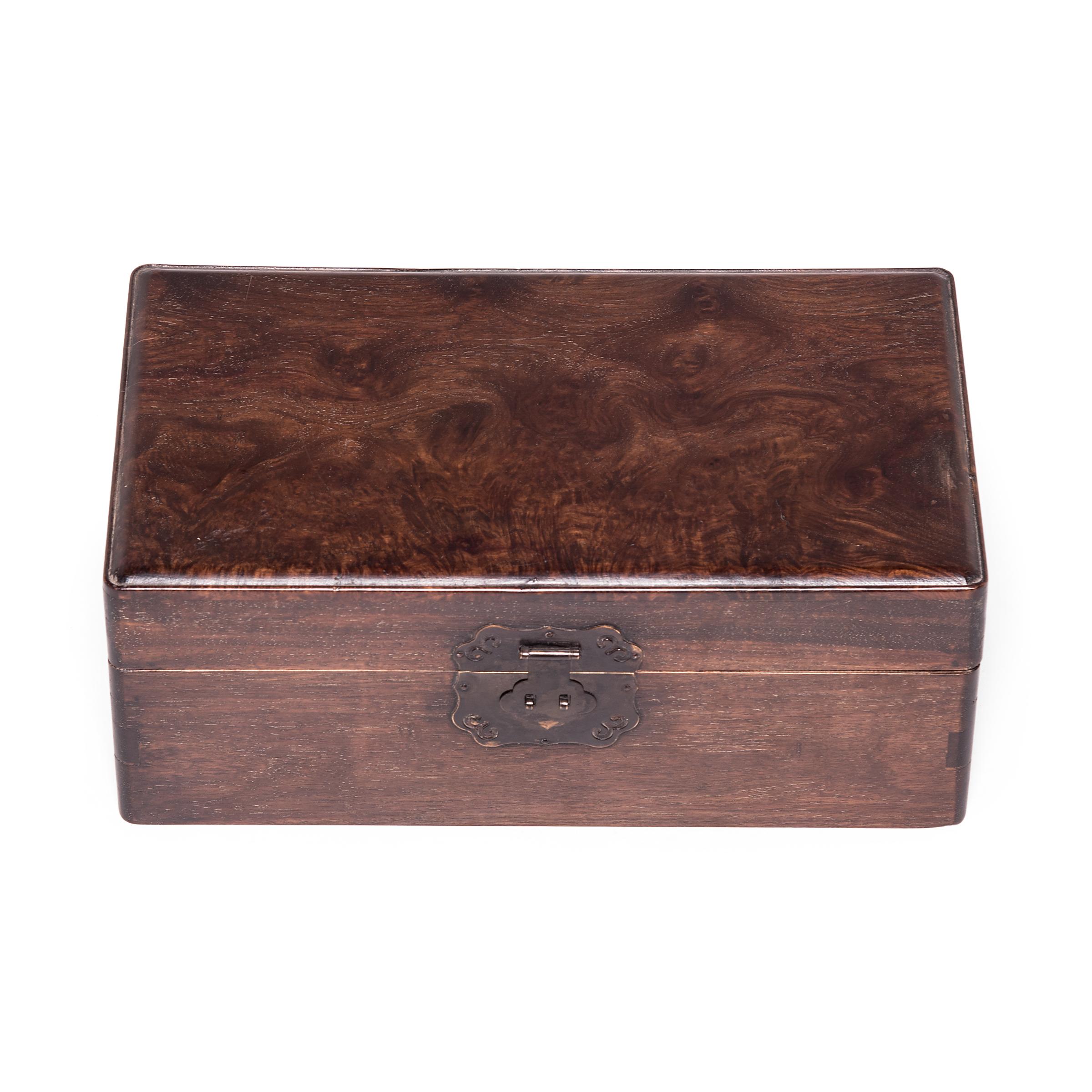 With clean lines and simple form, this refined 19th century lock box celebrates the beauty of huali wood, a rosewood valued highly for its abstract patterning and shimmering surface. The top surface of this box is made of huali burl wood, thought to