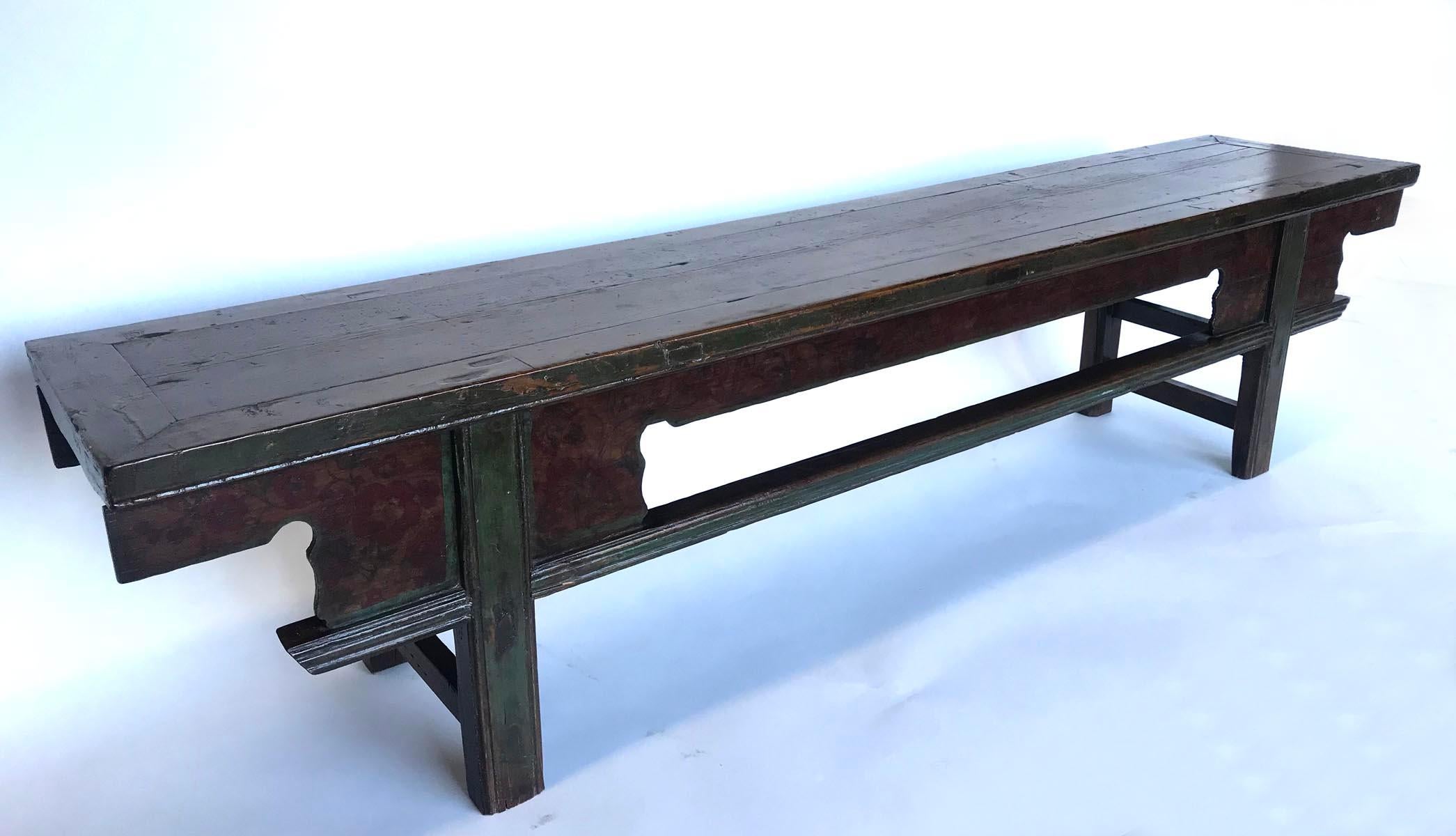 Old Chinese long elm bench with geometric multiple stretchers. Seat is framed. Some old green paint and faded barely visible red flowers on one long side of the bench. A handsome piece. Solid and functional.