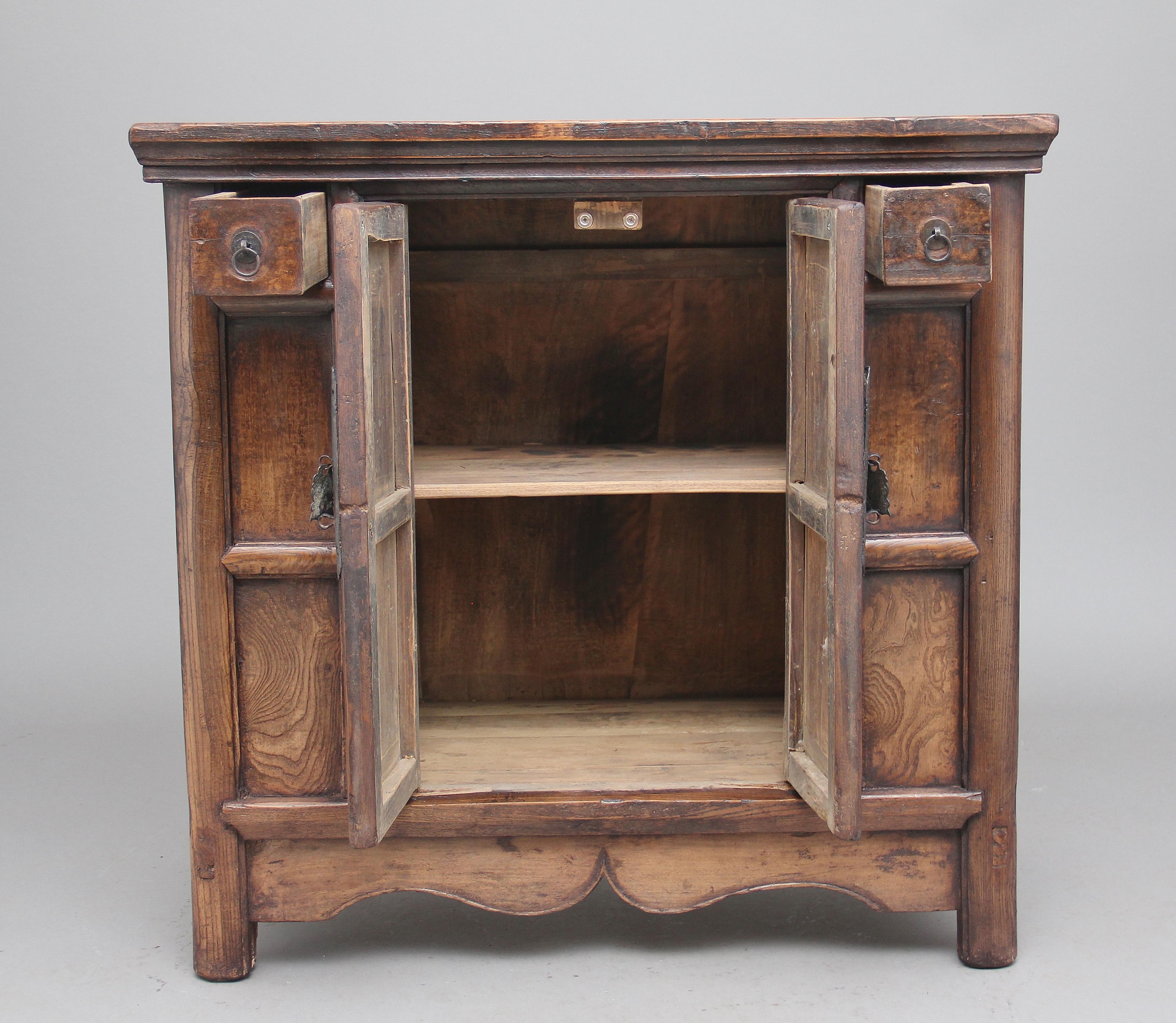 19th century Chinese elm rustic dresser of nice proportions, lovely figured panels, bold moldings, having a two door cupboard at the centre with original brass hardware, opening to reveal a fixed single shelf inside, flanked either side at the top
