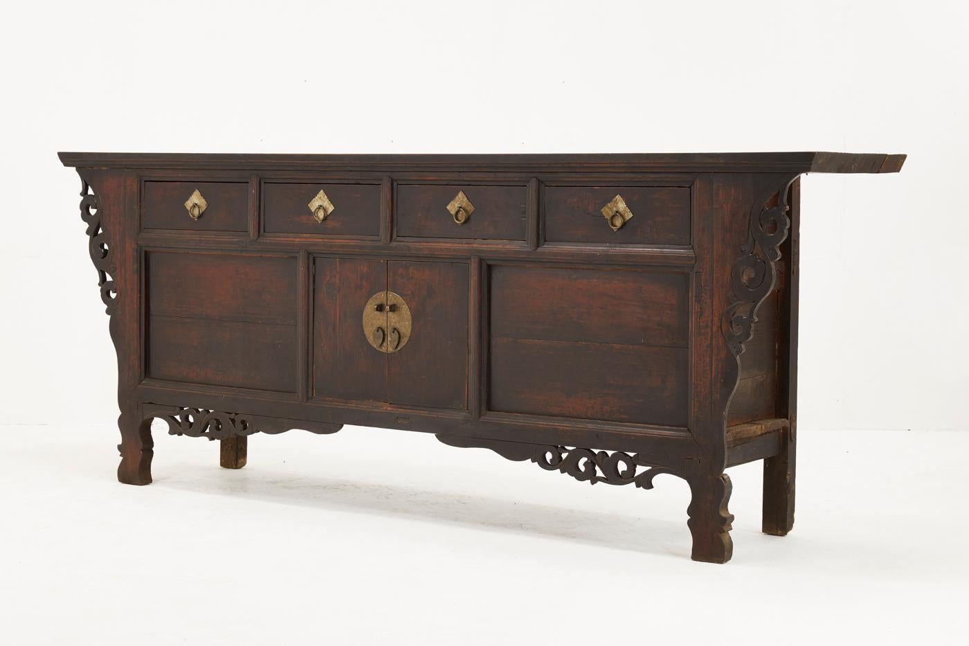 Superb example, 19th century Chinese sideboard in solid elm, retaining a wonderful untouched patina with carved decoration, brass handles and metalwork.