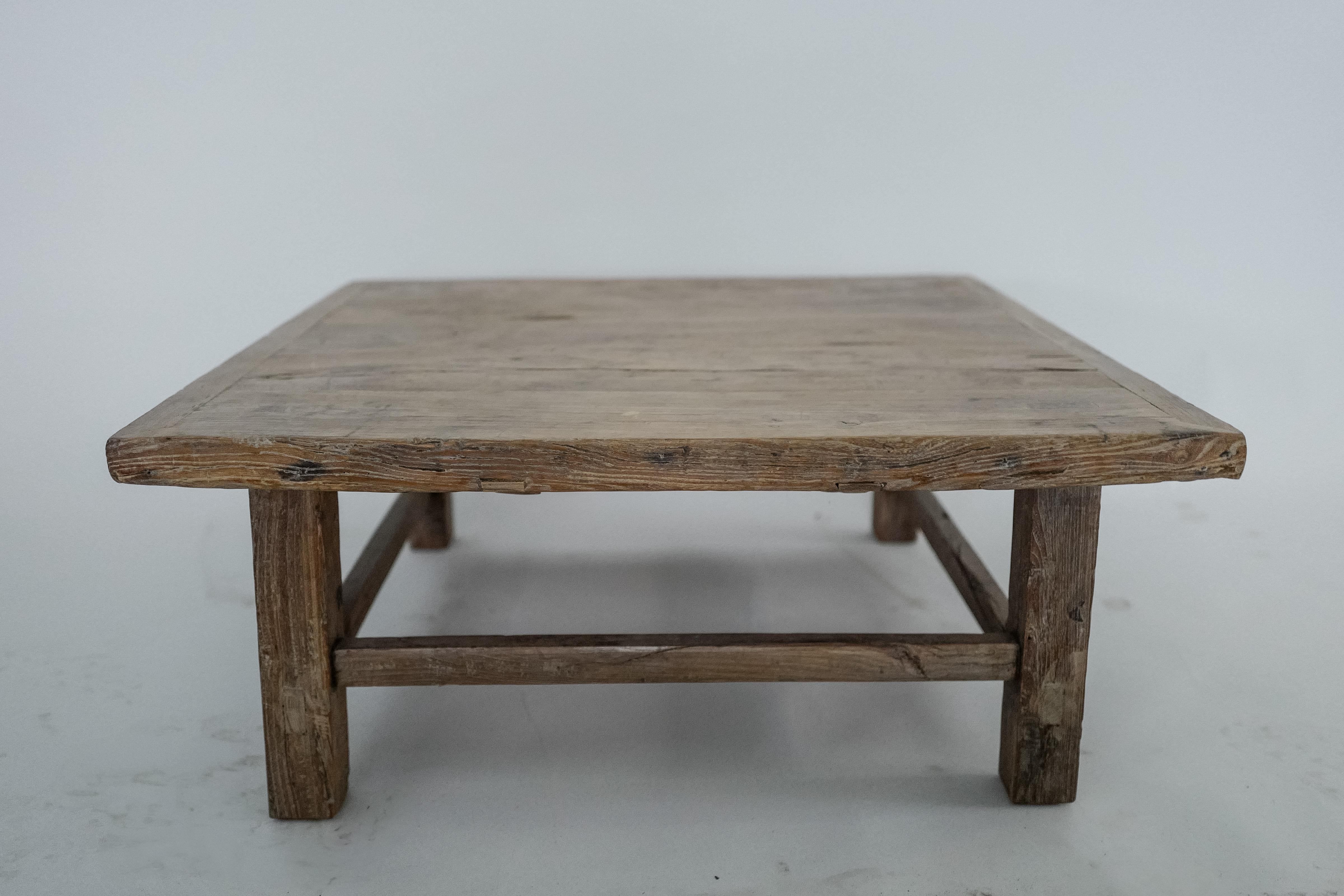 Cette table basse carrée chinoise antique du XIXe siècle témoigne de l'artisanat provincial chinois. Elle est fabriquée en bois d'orme durable et présente une patine authentique, usée par le temps. La construction artisanale et le grain de bois