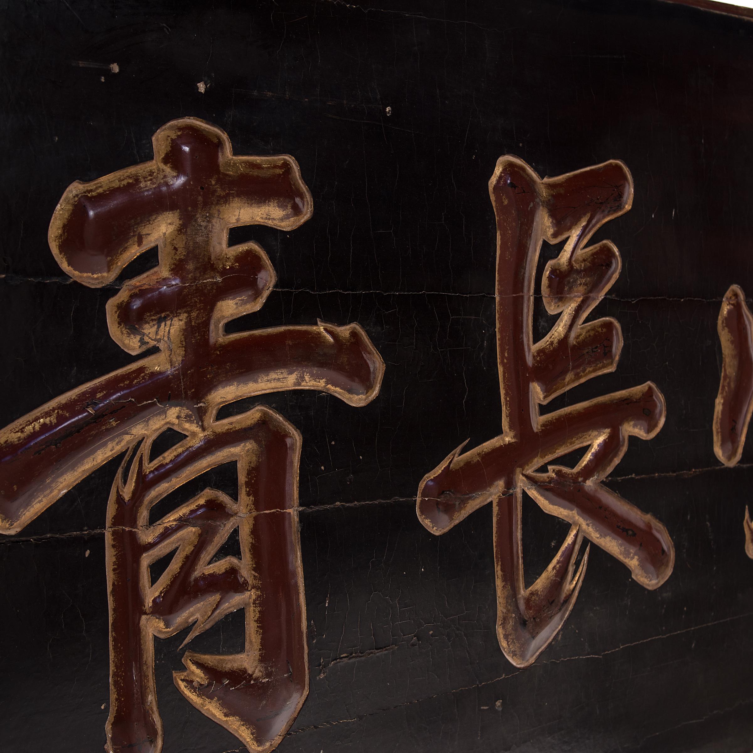 Dieses monumentale, lackierte Ulmenholz-Ehrenzeichen wurde Mitte des 19. Jahrhunderts in Nordchina geschnitzt. Die großen zentralen Schriftzeichen lauten 