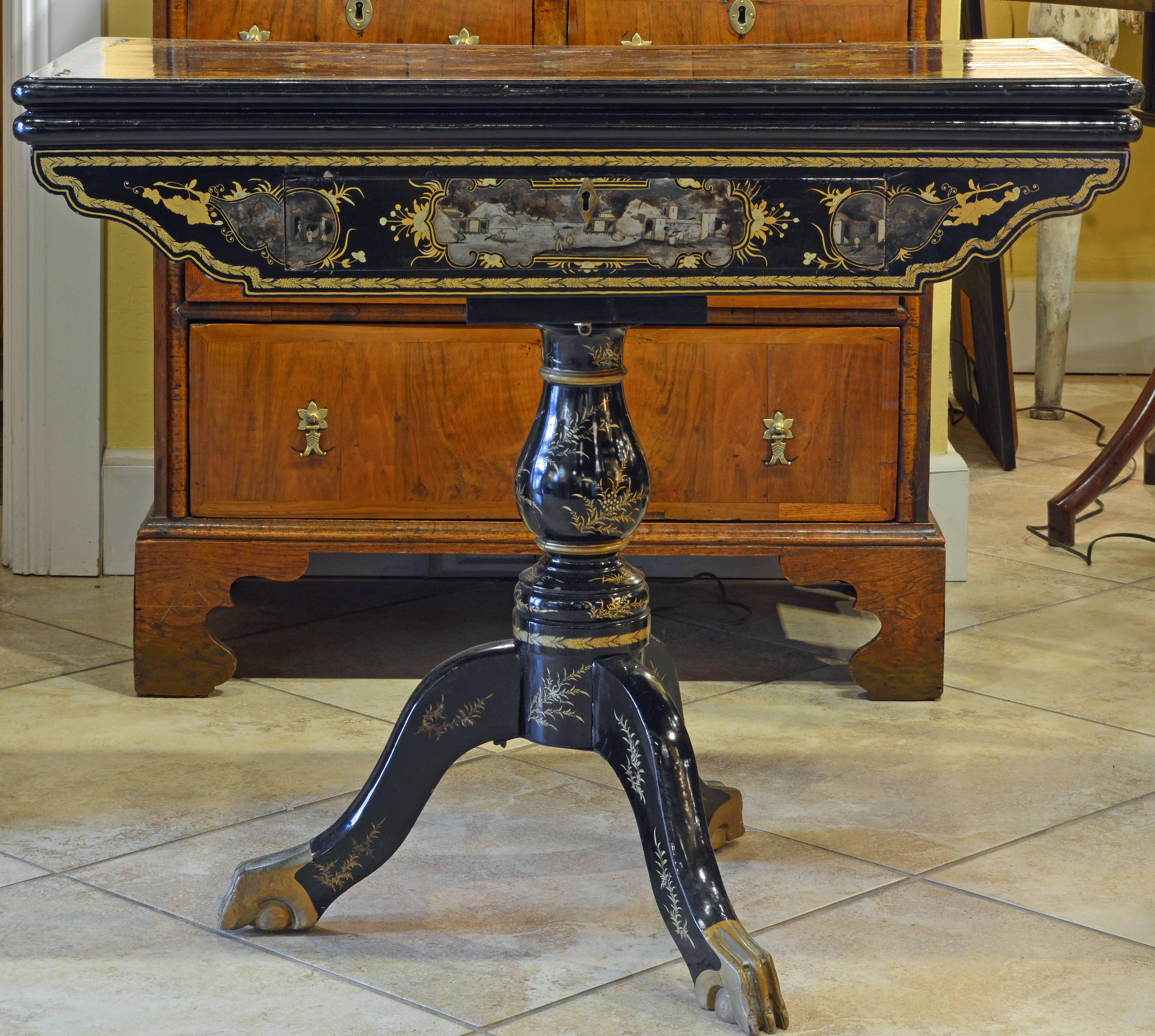 This black lacquer and gilt Chinese export game table features cartouches with stunning paintings of landscapes with people, buildings and boats rendered in a sophisticated and detailed manner. Under the top (which flips up and turns into full size)