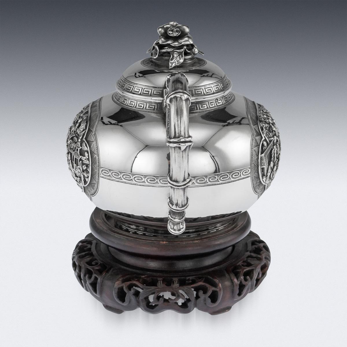 Antique 19th century exceptional Chinese export solid silver teapot, of round form resting on a flat base, the plain body applied with finely and profusely chased panels with figures in a landscape, surrounded by cross-key boarders, the handle and