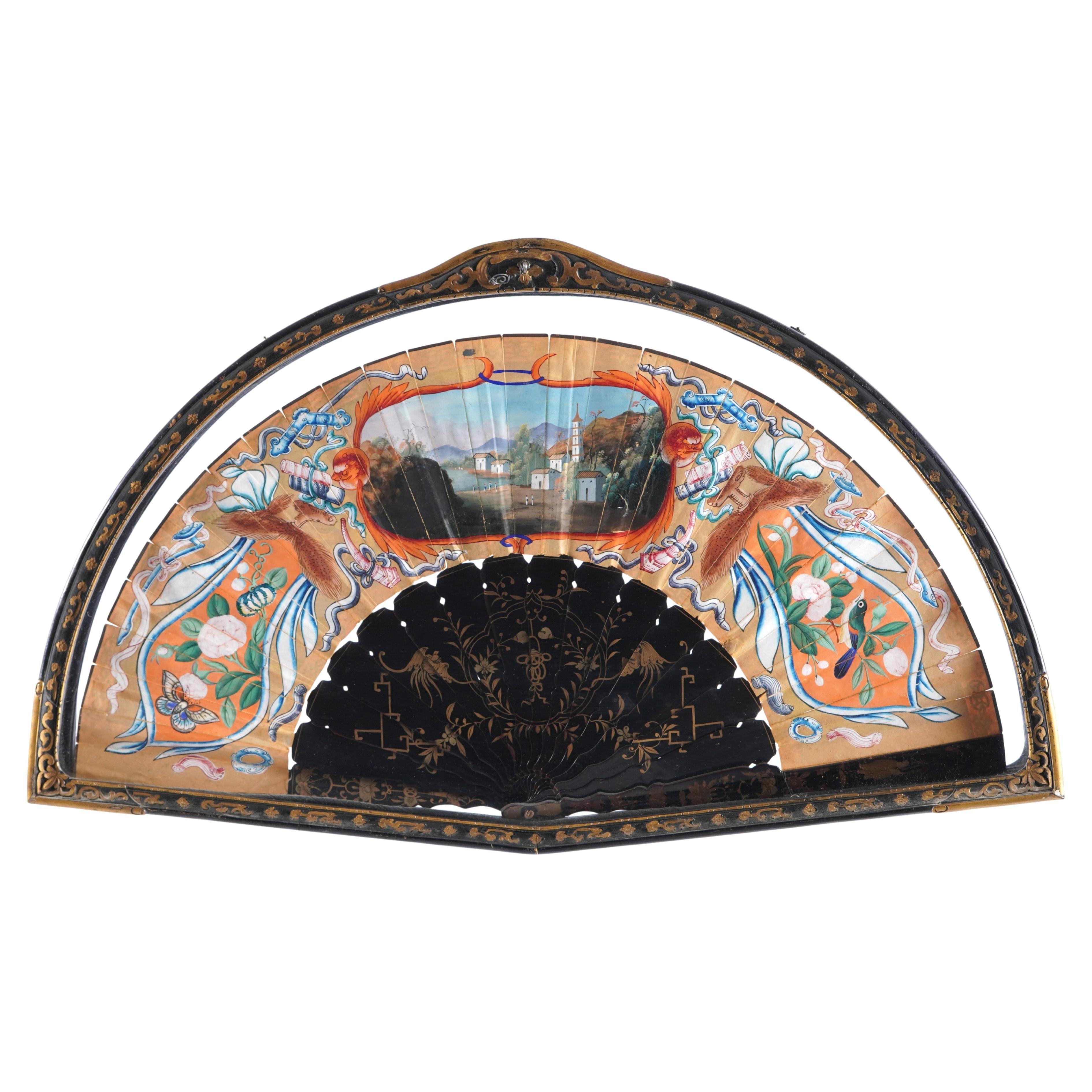 19th Century Framed Chinese Export Painted Fan. Delicate painted fan with courtyard scene of royal figure and attendants, mother of pearl or similar inlaid faces. Bordered top and bottom with auspicious items and geometric motifs. Center black and
