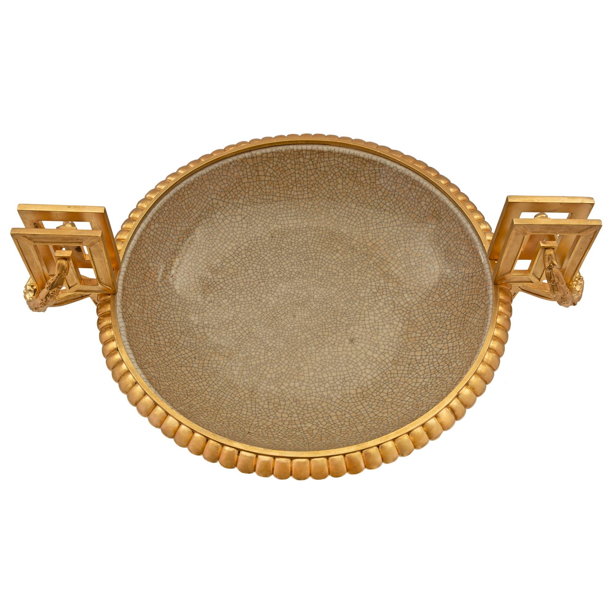 Magnifique coupe en porcelaine d'exportation chinoise du 19e siècle avec des montures en bronze doré de style Louis XVI du 19e siècle. L'urne est surélevée de huit pieds et possède une belle base carrée en bronze doré avec des coins concaves