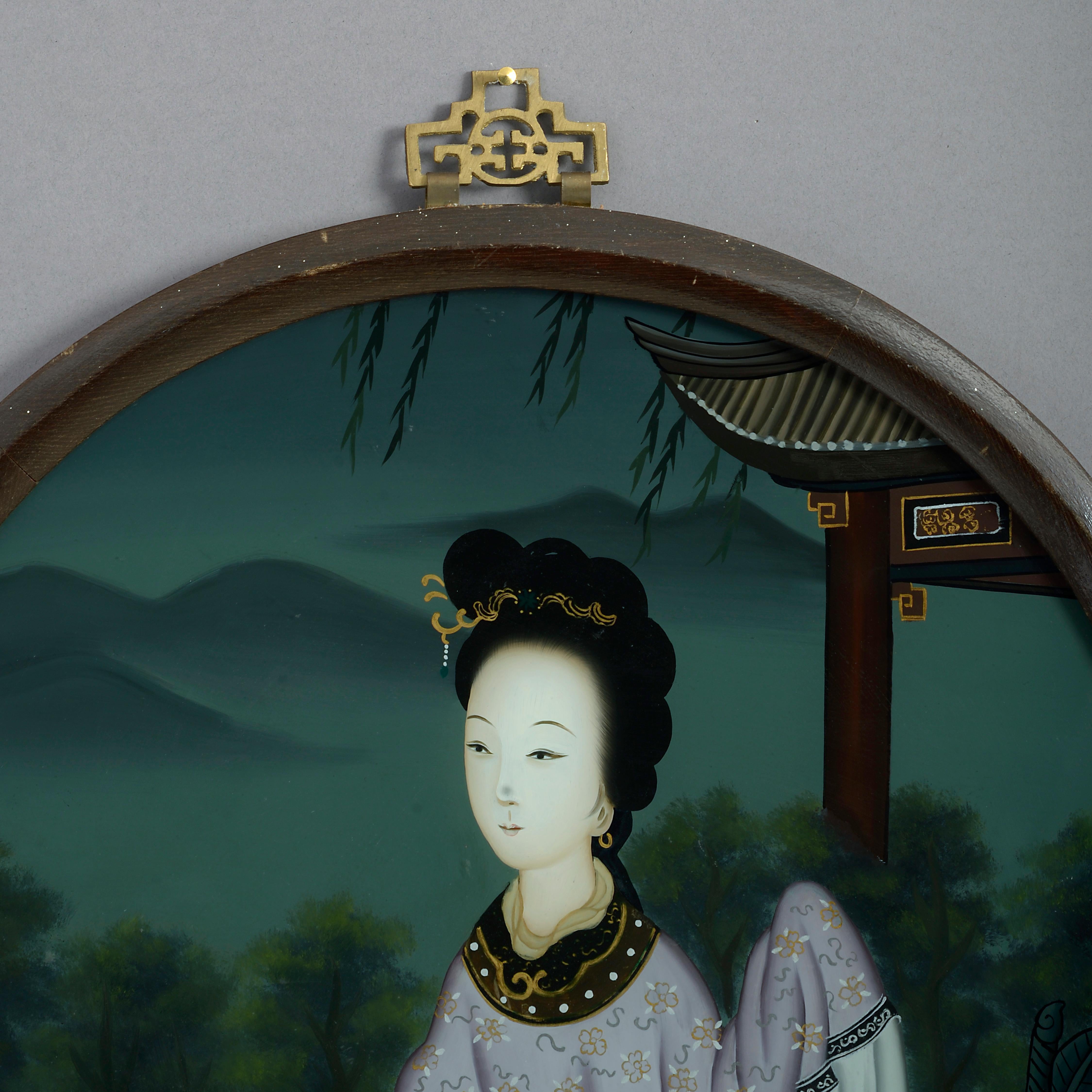 A late 19th century reverse glass painted portrait of a lady, by a pagoda within a mountainous landscape. Set within a circular wooden frame with pierced brass hanging plate.